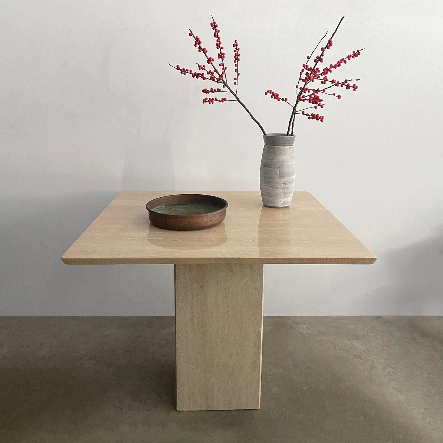 Italian travertine side table
Italy, circa 1970s 
Organic composition and feel 
Minimalist design with clean lines and neutral toned palette
Natural color variations throughout stone
Beveled edge top rests upon the square column base 
Texture and