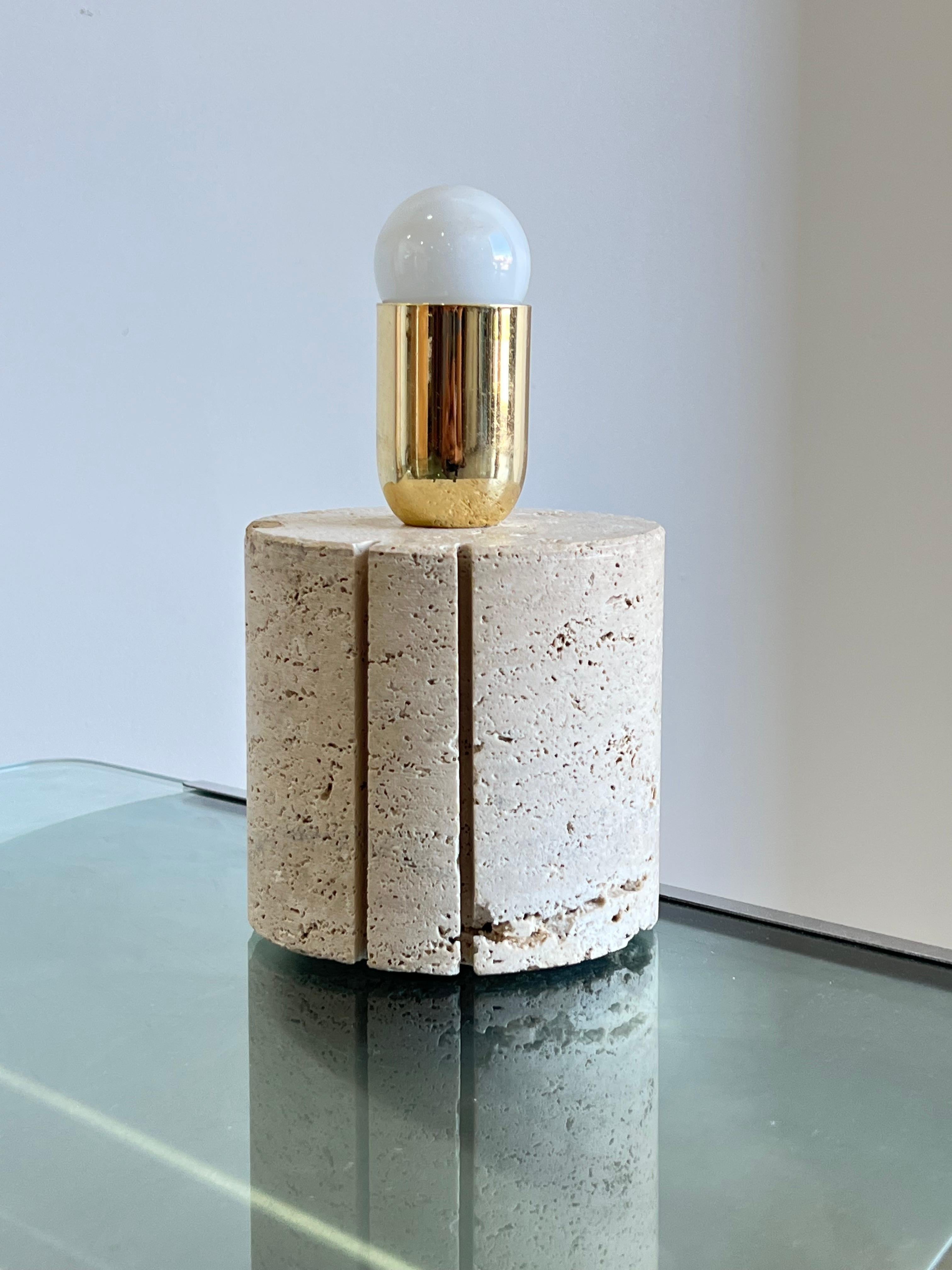Travertine and brass Italian Mid-Century Modern 1960s table lamp by Fratelli Mannelli. 
The base is super elegant and round shaped with 2 lines cut in the travertine.
Brass Light bulb holder.
The wiring is completely restored and in gold color.
 