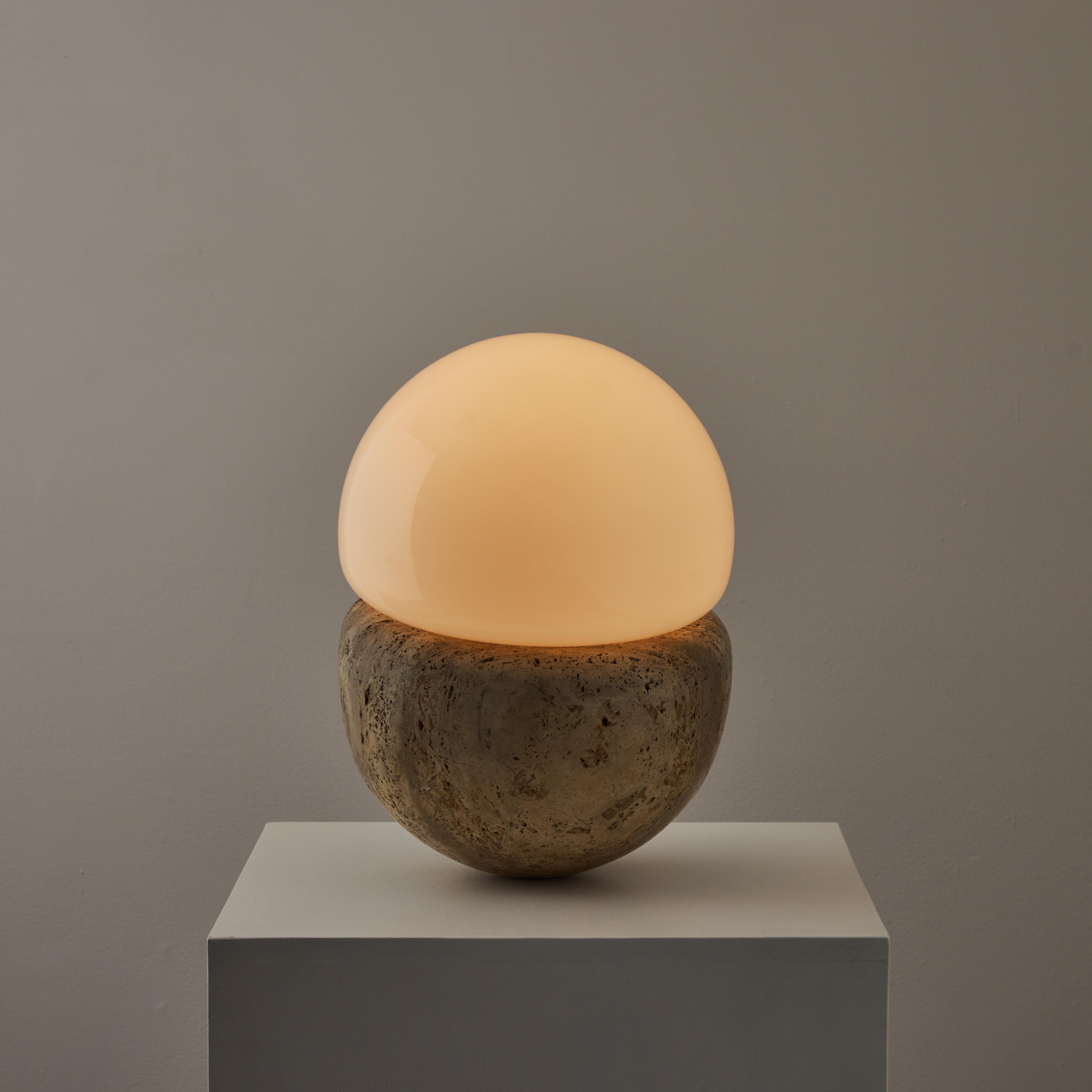 Italian Travertine Table Lamp. Manufactured in Italy, circa 1960s.. Extremely heavy duty travertine base paired along with an opal glass diffuser. The sconce holds a single e27 socket type adapted for the US. We recommend a 40 to 60 w LED equivalent