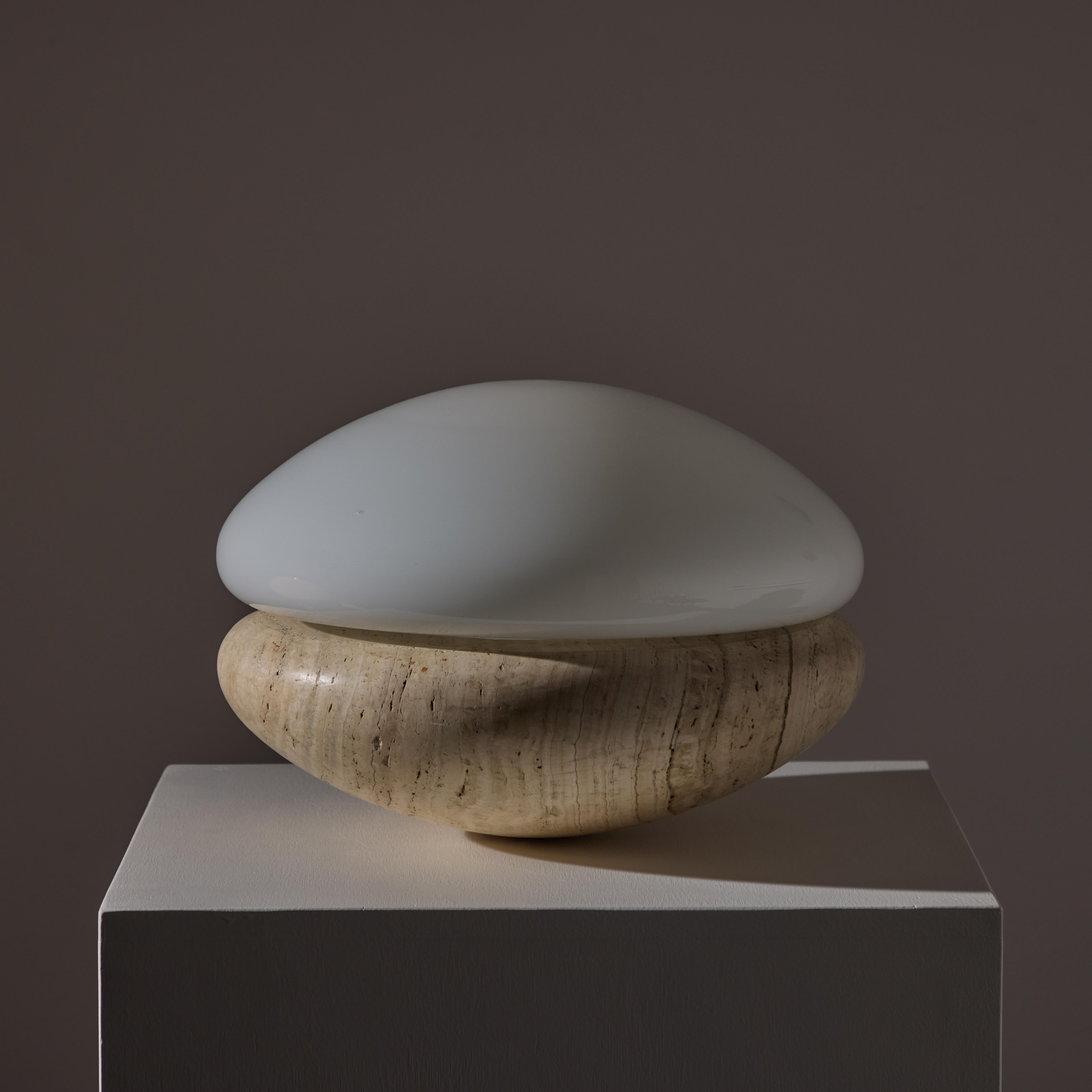 Italian Travertine Table Lamp. Manufactured in Italy, circa 1960s. Extremely heavy duty travertine base paired along with an opal glass diffuser. The sconce holds a single e27 socket type adapted for the US. We recommend a 40 to 60 w LED equivalent