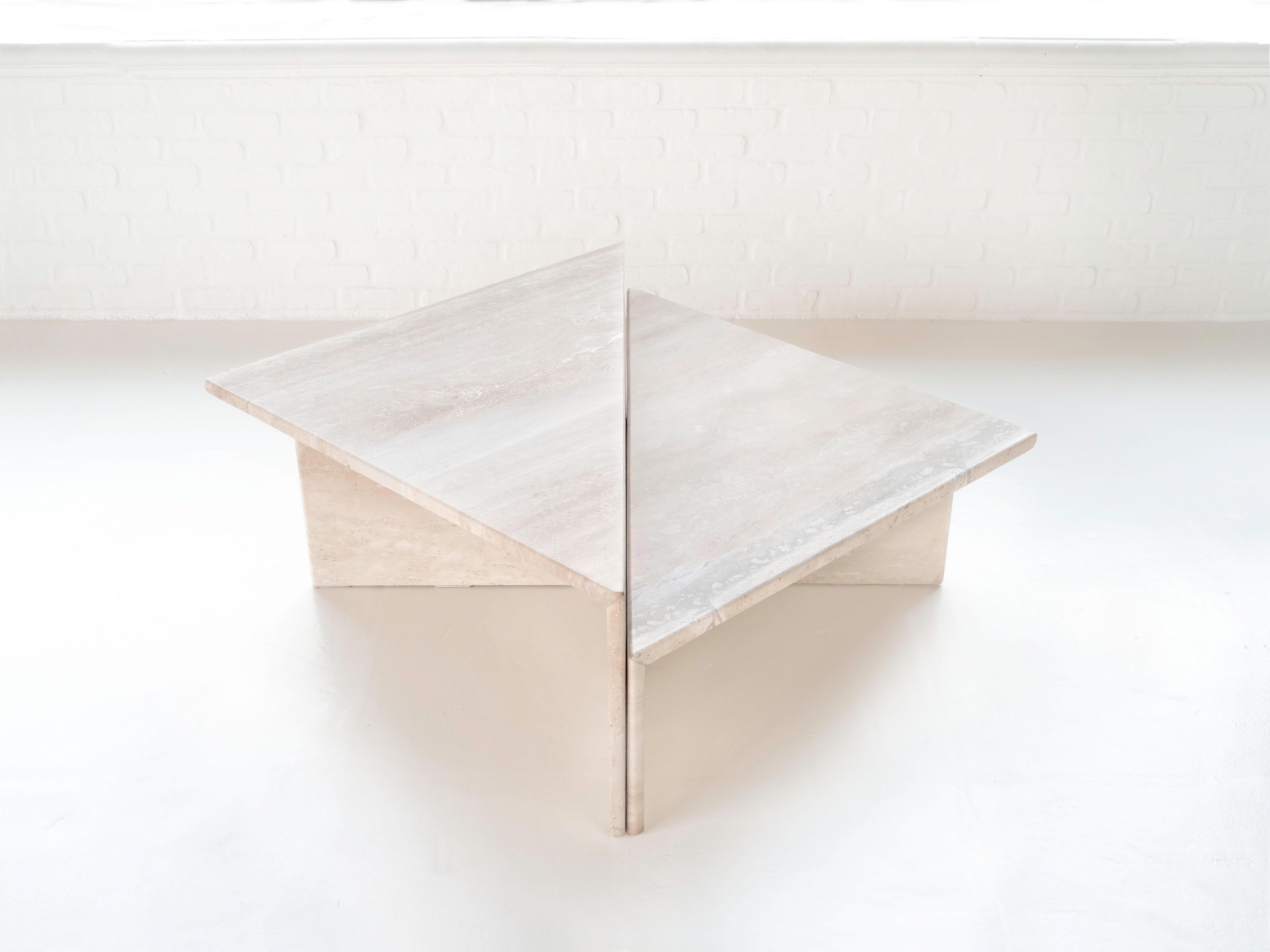 Made from Italian Travertine, circa 1970s. The tables are triangular, when placed together they form a square. One table is slightly higher than the other which creates a tier when fit together. The tables have been resurfaced and sealed. Only