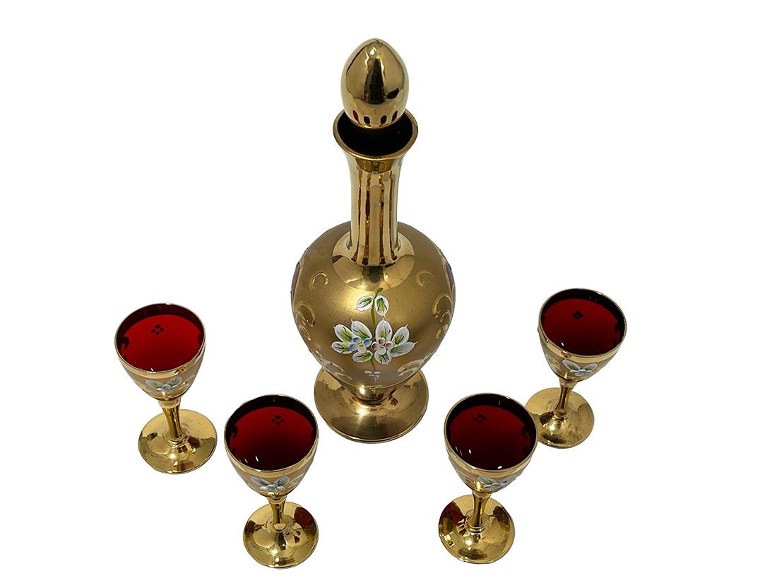 Italian Tre Fuochi Ruby red crystal glass liquor set, 1950s

An Italian Tre Fuochi liquor set in ruby ​​red crystal glass with hand-decorated flowers and gold paint with scroll motif pattern in relief. A decanter and four liquor glasses. The