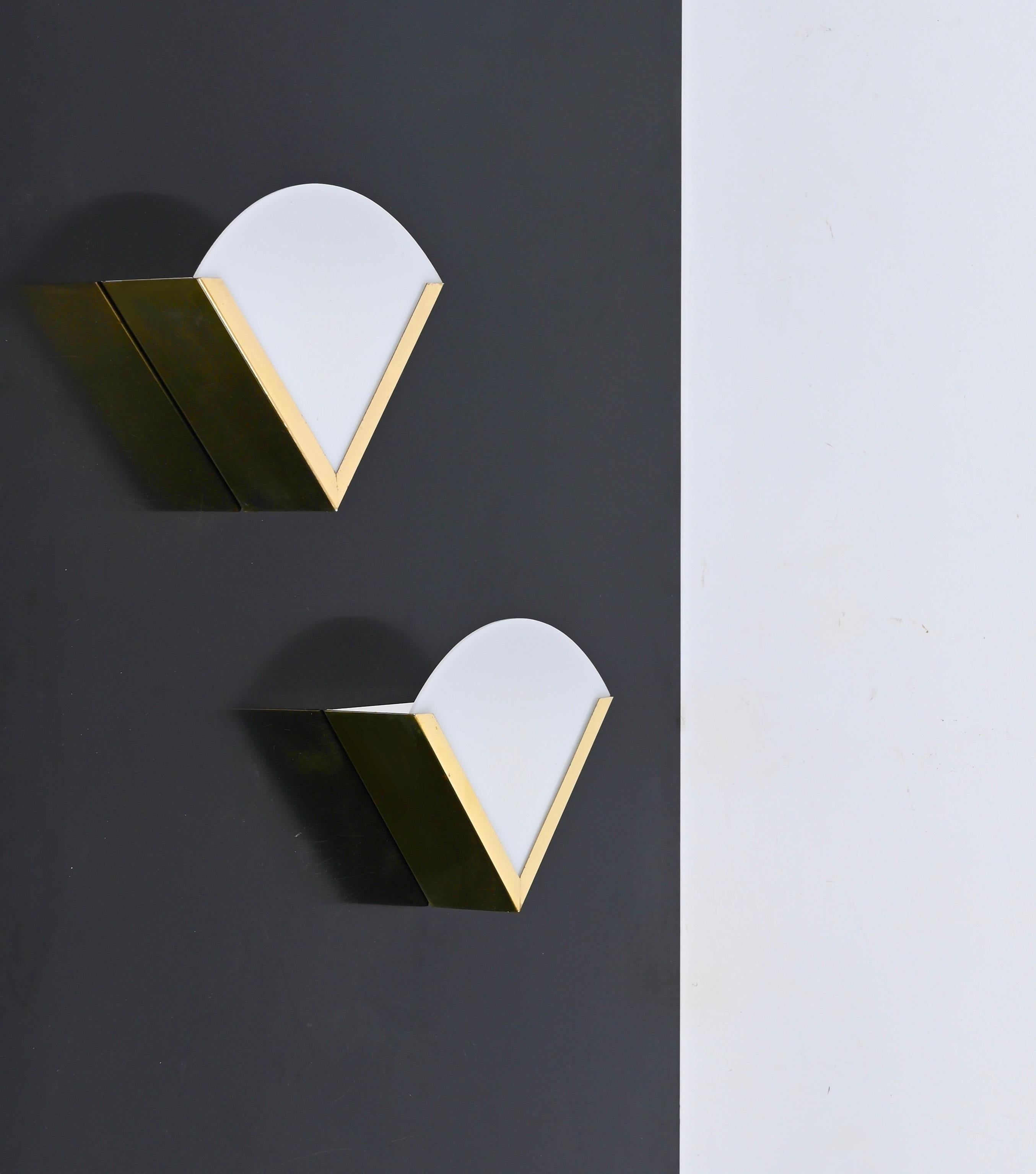 Gorgeous Mid-Century sconces made in brass and white perspex. These elegant wall lamps were designed in Italy during the 1970s. 

The sconces feature a triangular body fully made in brass with a white perspex shade. The contrast between the gold of