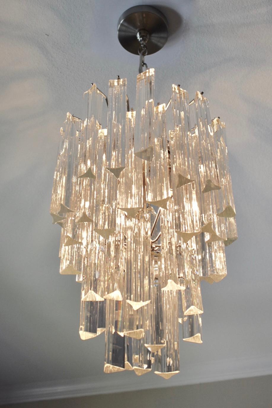 Venini style tiered triedri or triedi crystal prism chandelier with nickel plated steel frame. Fixture uses 3 - 40 watt recommended B/candelabra base bulbs or any wattage LED candelabra base bulb. Newly wired for US. 

Fixture is 20