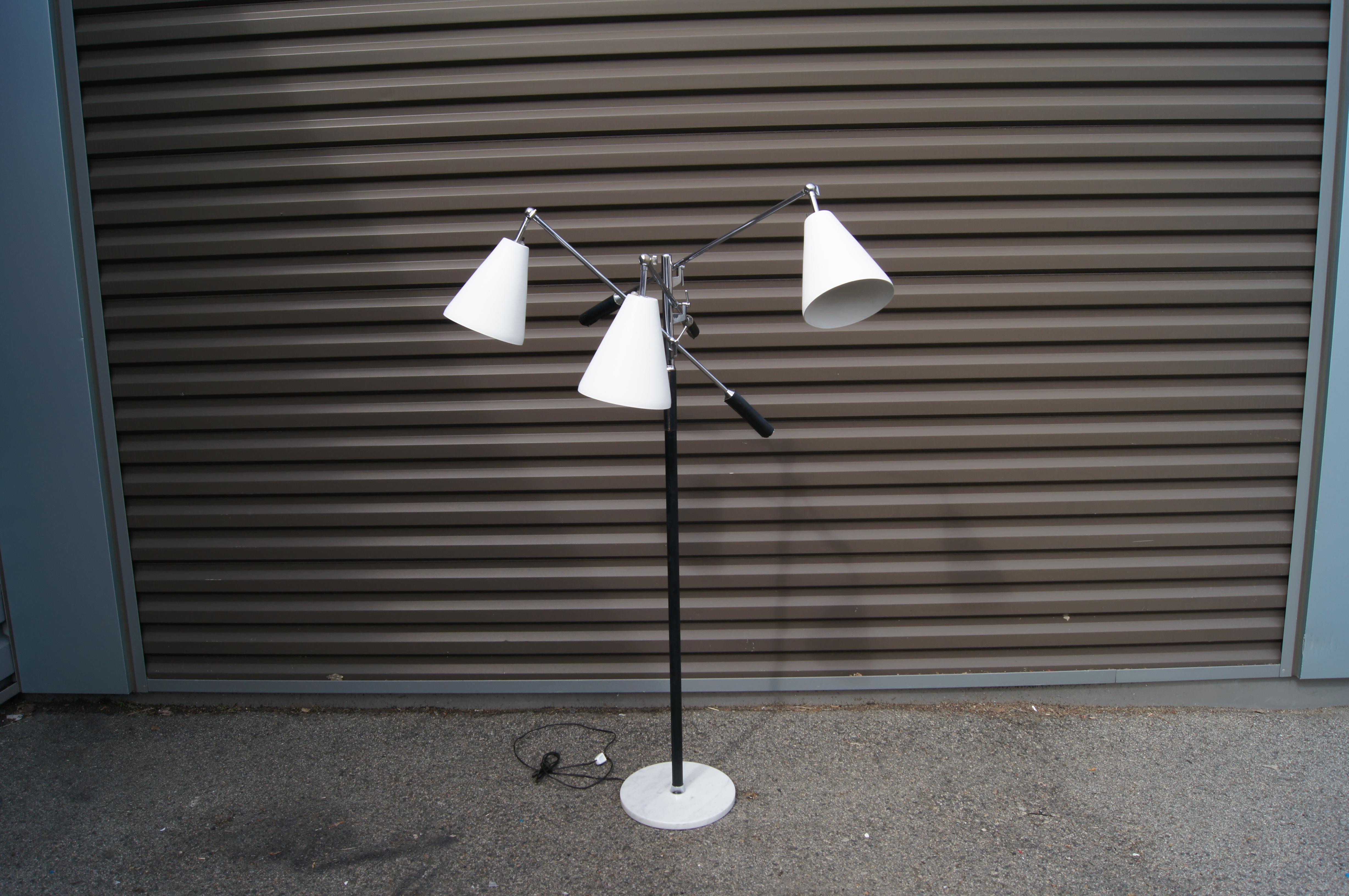 This 1960s triennale floor lamp in the style of Arredoluce was manufactured in Italy for the American lighting company Koch & Lowy. A black-enameled chrome post rises from a round marble base. Three chrome arms with stitched leather sleeves end in
