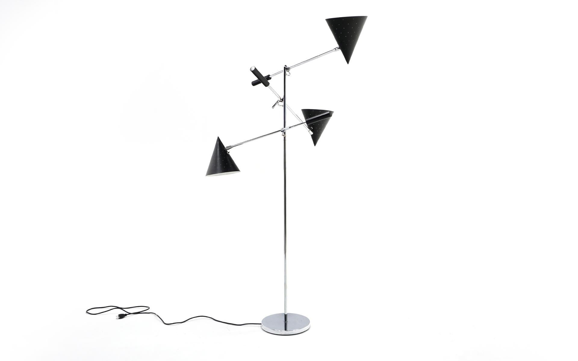 Three arm floor lamp in the style of Arredoluce. Chromed steel base, central support and arms. Black enameled perforated shades make for a striking appearance when turned on. There are individual switches for each shade. Base diameter is 11.25