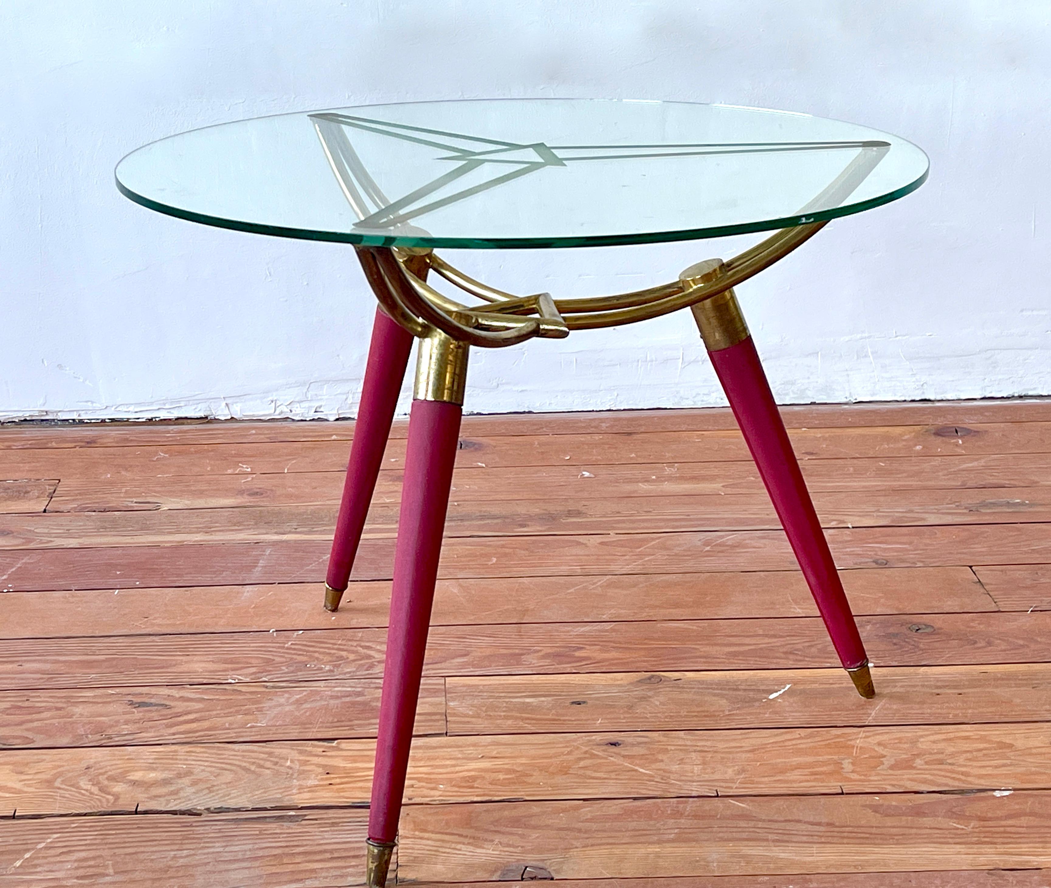 Italian side table with tripod base and sculptural Brass triangular base and red tapered legs. 
Fantastic piece.
Italy, 1950's.