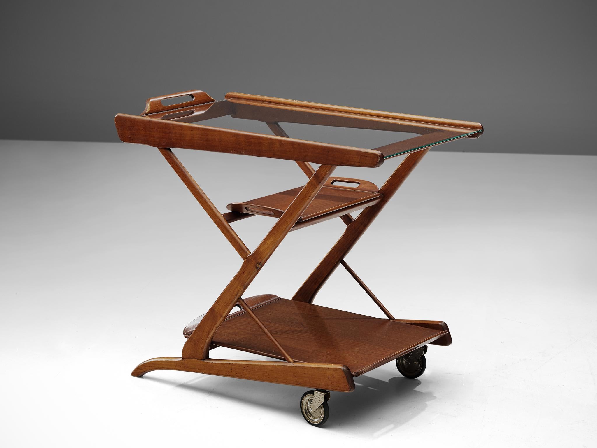 Trolley, dark wood and glass, Italy, 1960s.

This trolley is executed with a wooden frame, glass top and metal wheels. A composition of strong lines that create a Z-shape from the side. The two removable trays turn this trolley into a versatile