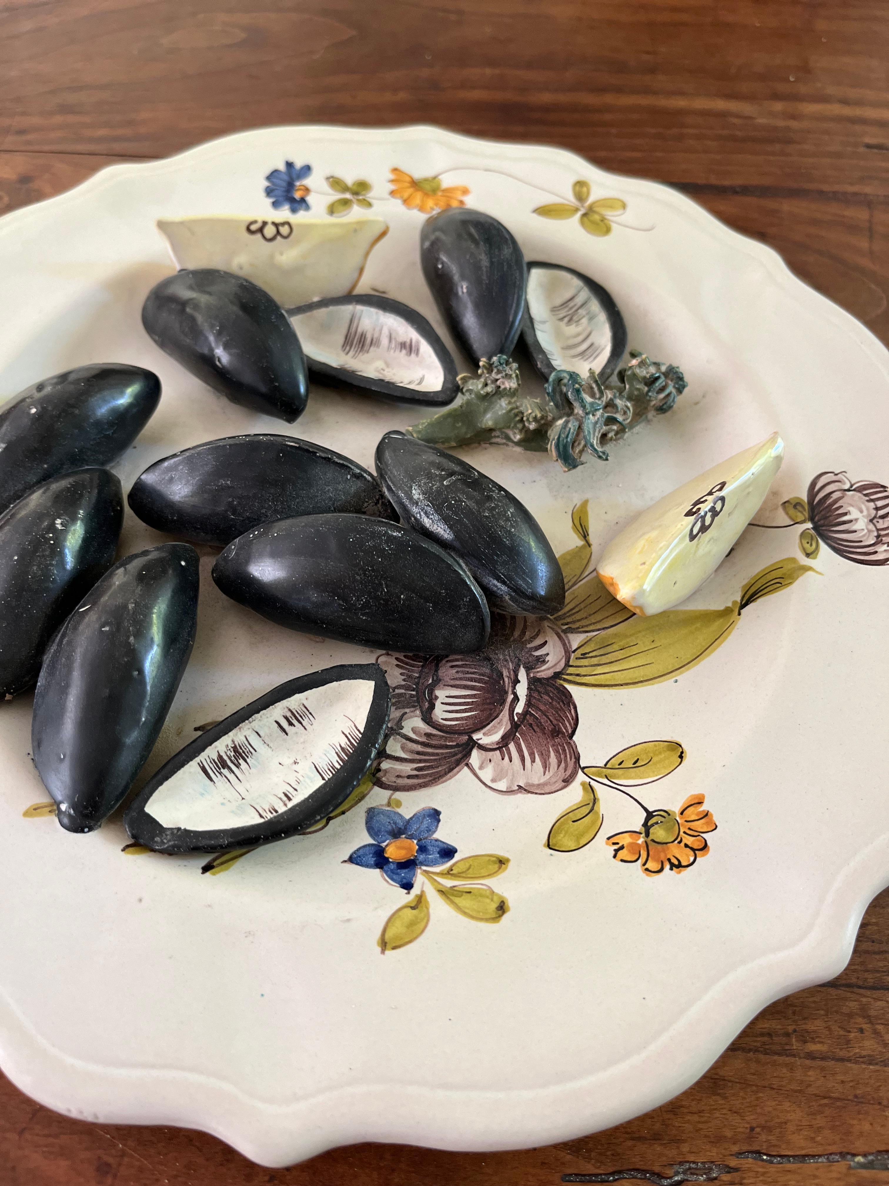 An early to mid 20th century faience Trompe L’oeil decorative plate with faux mussels and lemons on a scalloped plate. Marked in reverse “Italy”.  