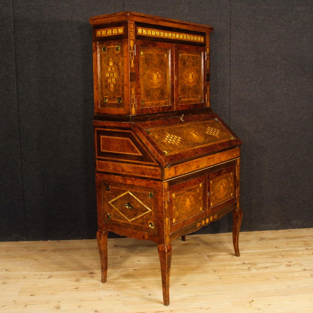 Italian trumeau from 20th century. Double body cabinet in richly inlaid wood in various precious woods and fake mother-of-pearl. Lower body with two doors and fall-front. Interior with writing desk covered in fabric with some signs of wear and four