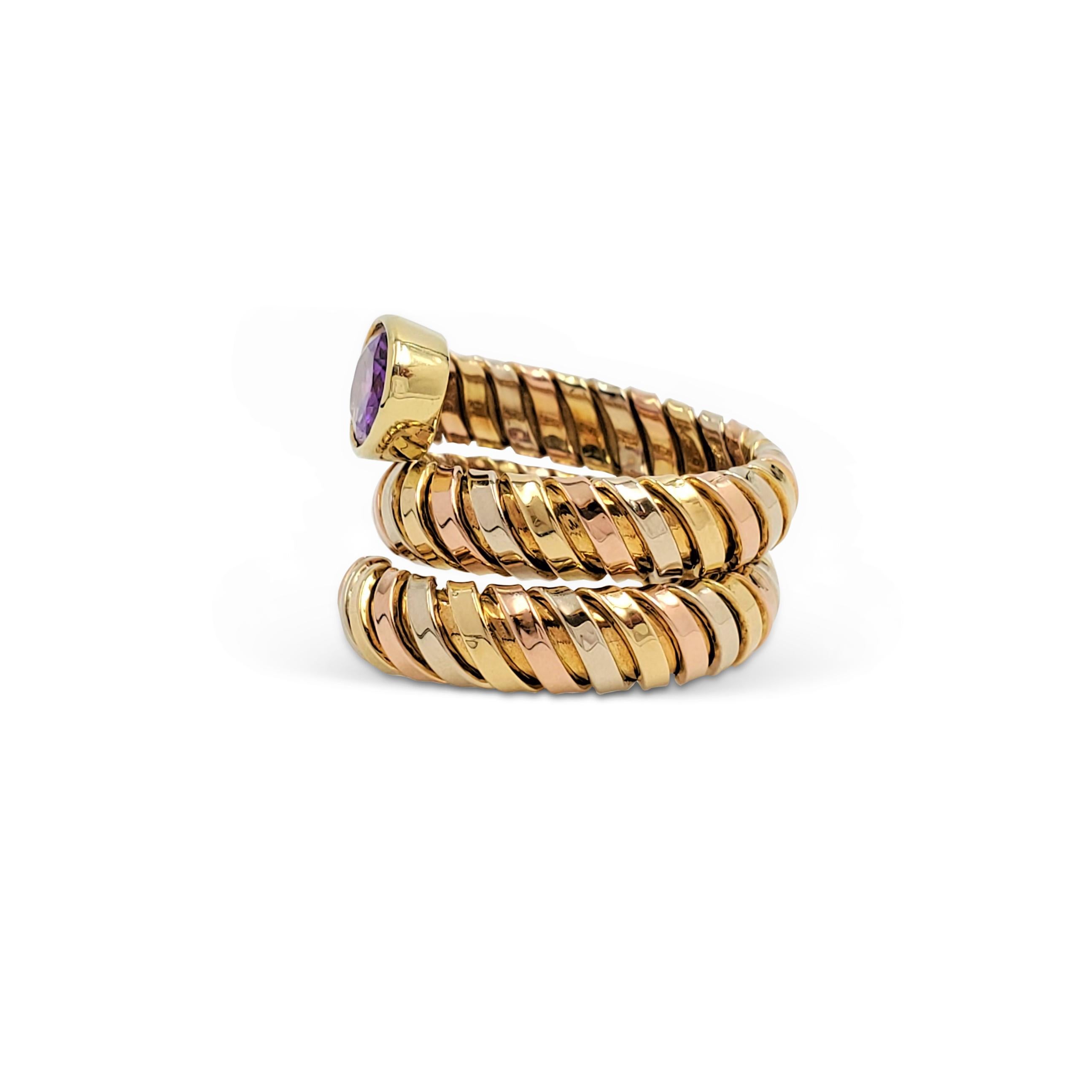 Intriguing spiral ring crafted in 18 karat Yellow, Rose, and White gold in the 'tubogas' style made famous by Bvlgari. Set with a lovely faceted oval cut amethyst, the ring sits comfortably on the finger thanks to its spiraled construction. US size