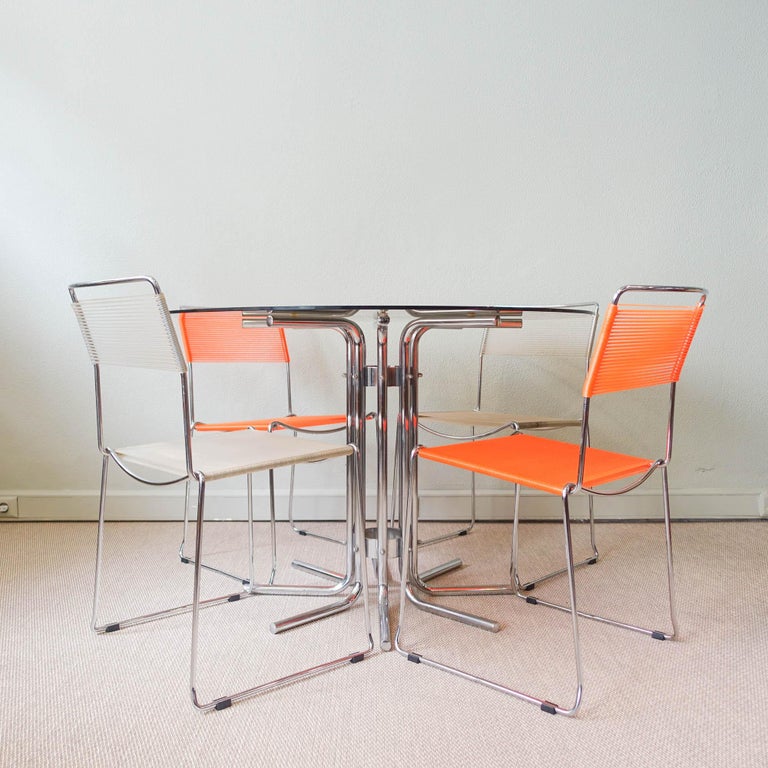 This dining table was designed and produced in Italy during 1970's. The structure as a central foot and is made of chromed steel tubes with the top in smoked glass. The glass top has a small chip. It is in a good and original condition.