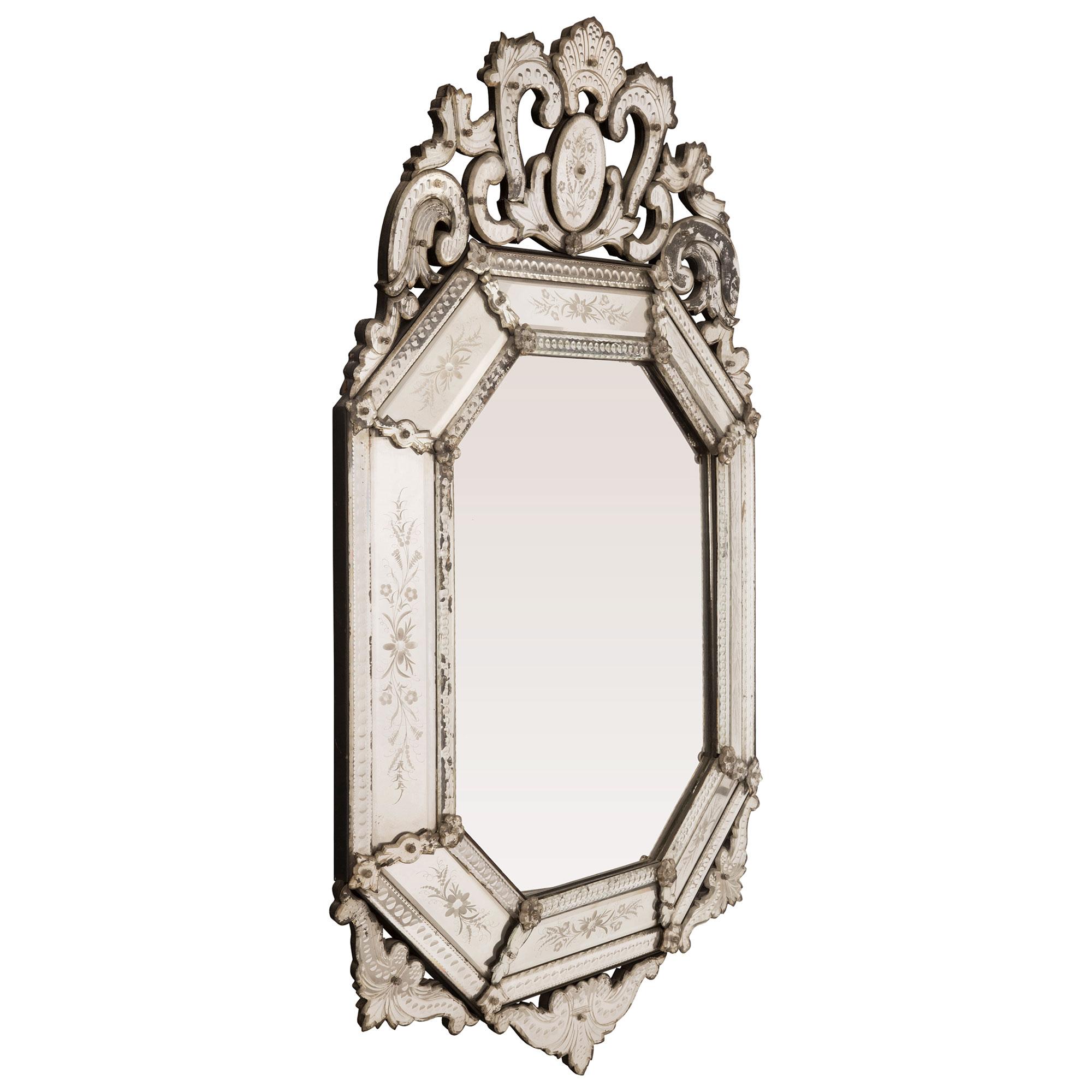 Superbe miroir italien du début du siècle, à double encadrement, de style vénitien. Le miroir de forme octogonale a conservé toutes ses plaques d'origine, la plaque centrale étant encadrée d'un ravissant motif perlé. Les plaques de miroir