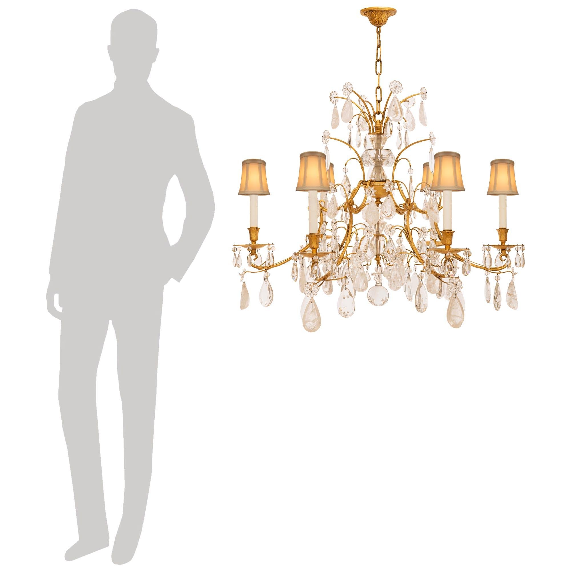 A stunning and most attractive Italian Turn of the Century Louis XV st. Gilt Metal and Rock Crystal chandelier. The wonderful six arm chandelier is centered by a solid spherical bottom Crystal pendant below the central fut and surrounded by a