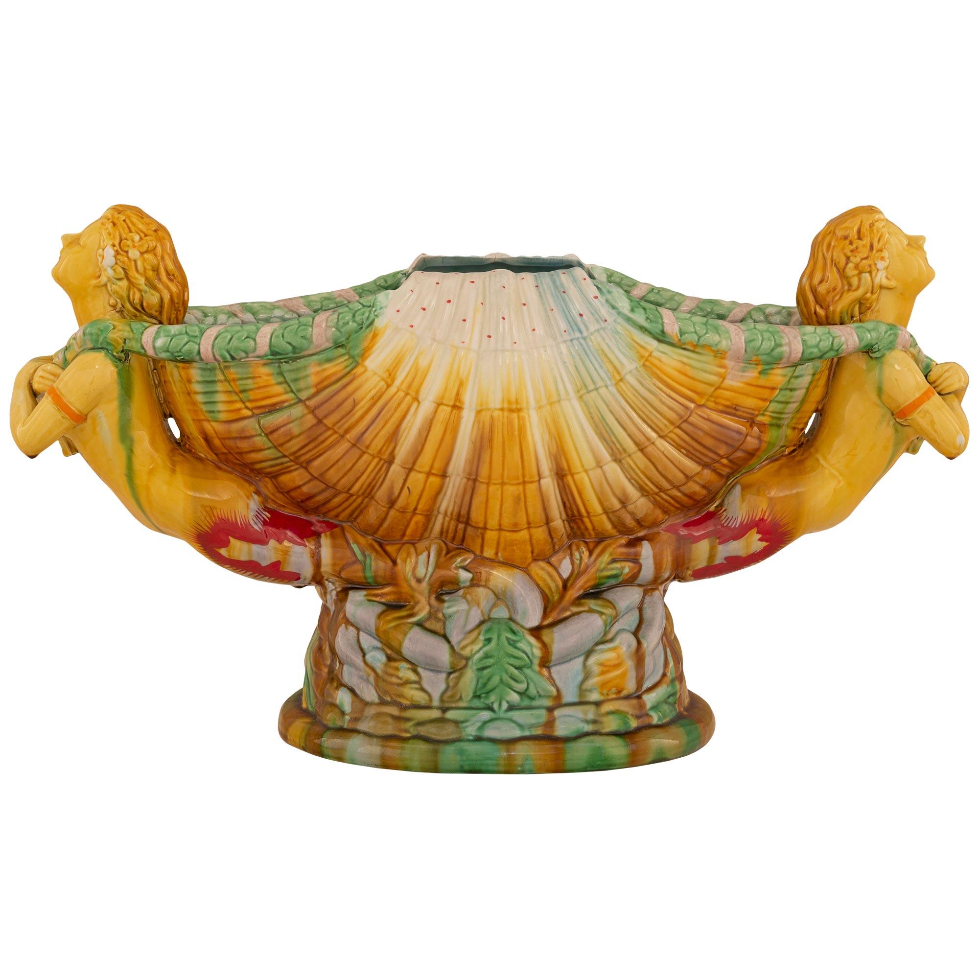 A striking and most decorative Italian turn of the century Majolica porcelain centerpiece bowl. The centerpiece is raised by an oblong base with a fine rock like design and fine intertwining patterns. The bowl displays a stunning and most decorative