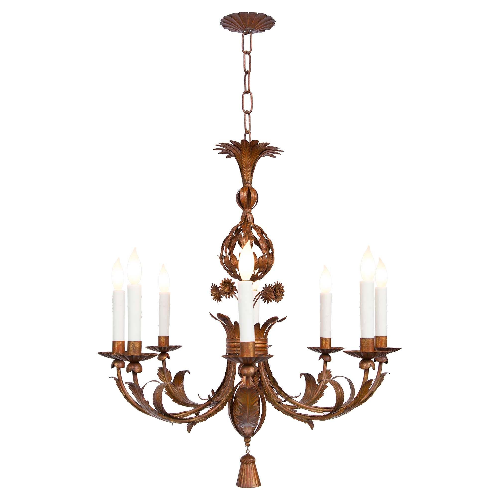 Un bellissimo lampadario a otto bracci in metallo stampato di fine secolo. Il lampadario è centrato da un affascinante ciondolo a nappe sotto movimenti fogliacei che si diramano e adornano ogni braccio. Al centro c'è un disegno a forma di corona con