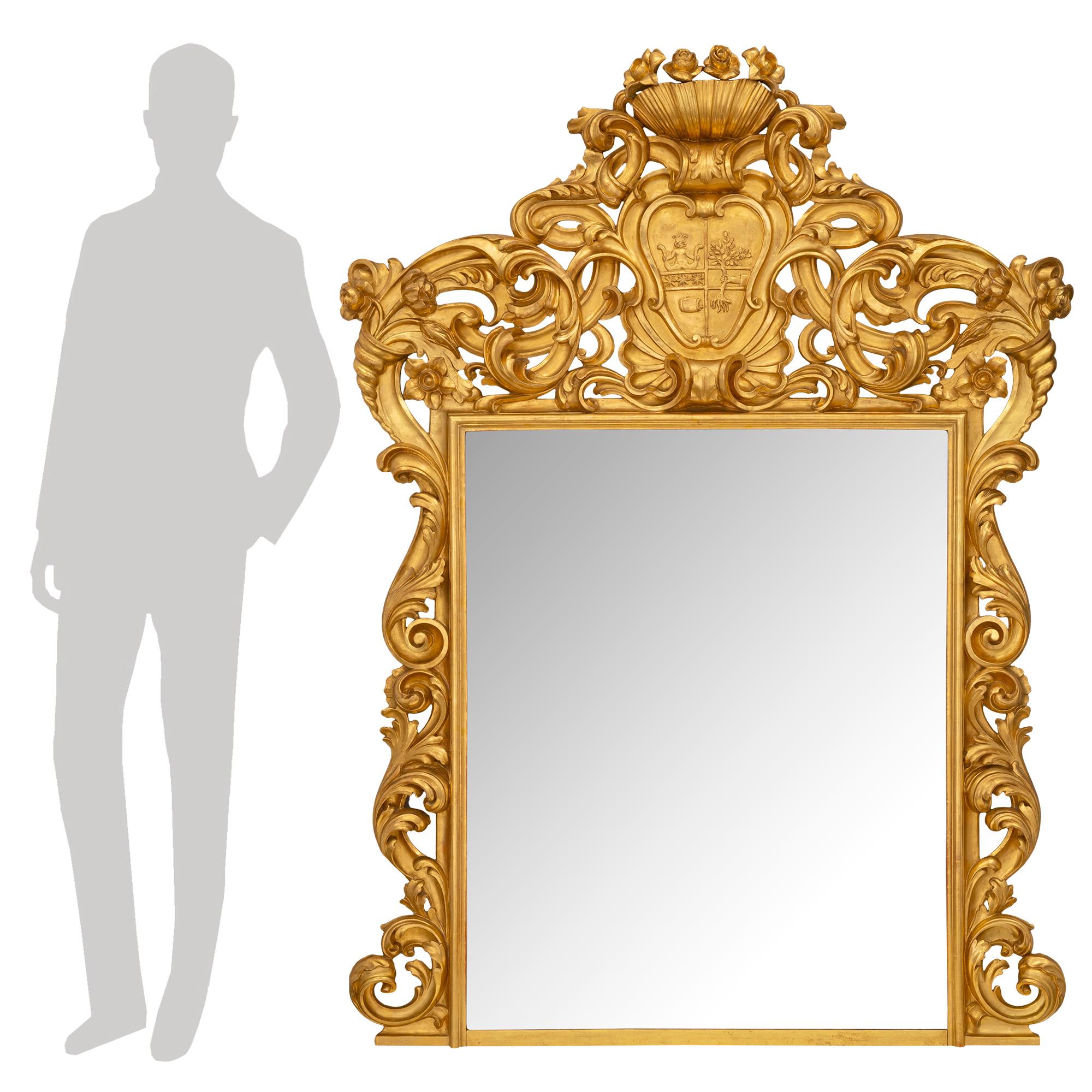 A beautiful Italian turn of the century Roman giltwood mirror. The original mirror plate is fitted within a fine mottled giltwood frame with stunning pierced scrolled foliate movements leading up each side above a fine straight base. The majestic