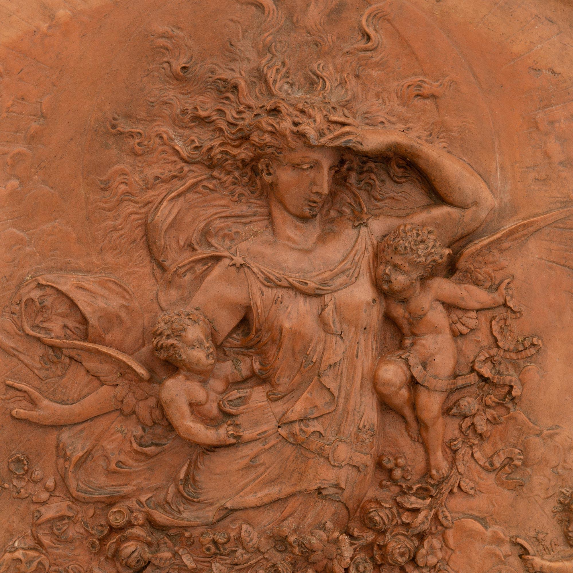 A unique and finely detailed Italian turn of the century Terra Cotta plaque of the goddess Flora. This elegant circular plaque is centered around a recessed panel of the Roman goddess of flowers and spring, Flora. Flora is depicted in a flowing robe