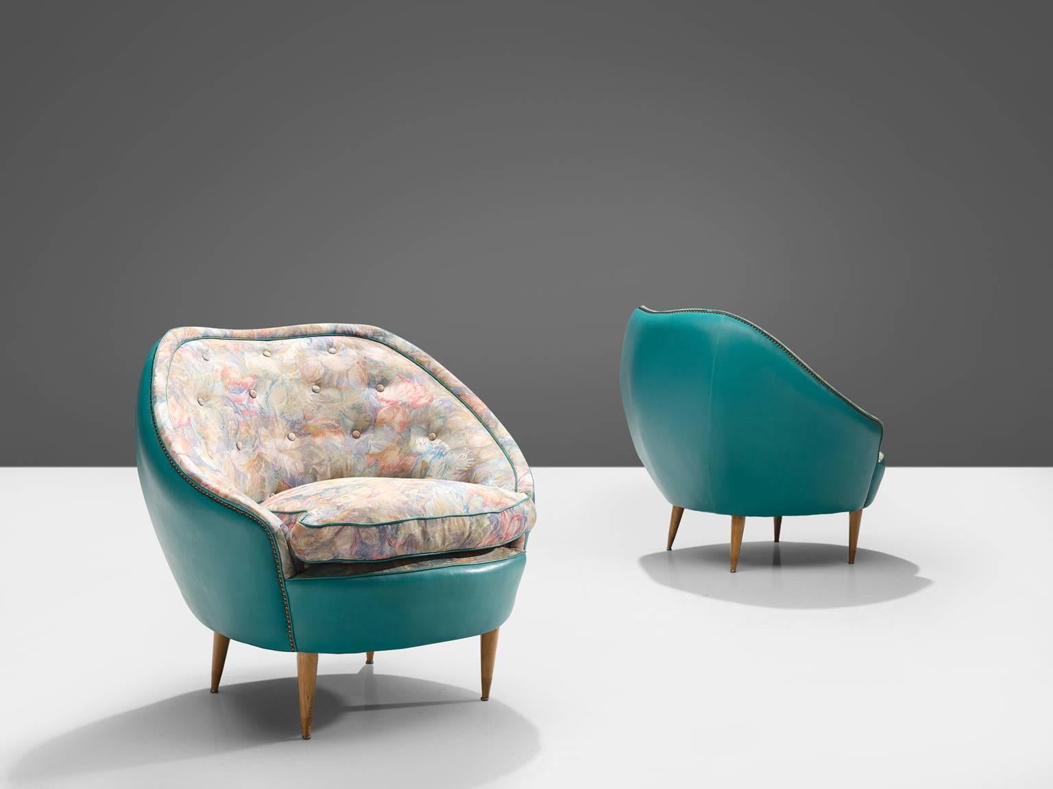 Lounge chairs, turquoise leatherette, fabric, wood, Italy, 1950s.

These club chairs show traits of the design by the Italian designer Veronesi. They are elegant yet bulky and are completely rounded when seen from behind. The chairs feature a