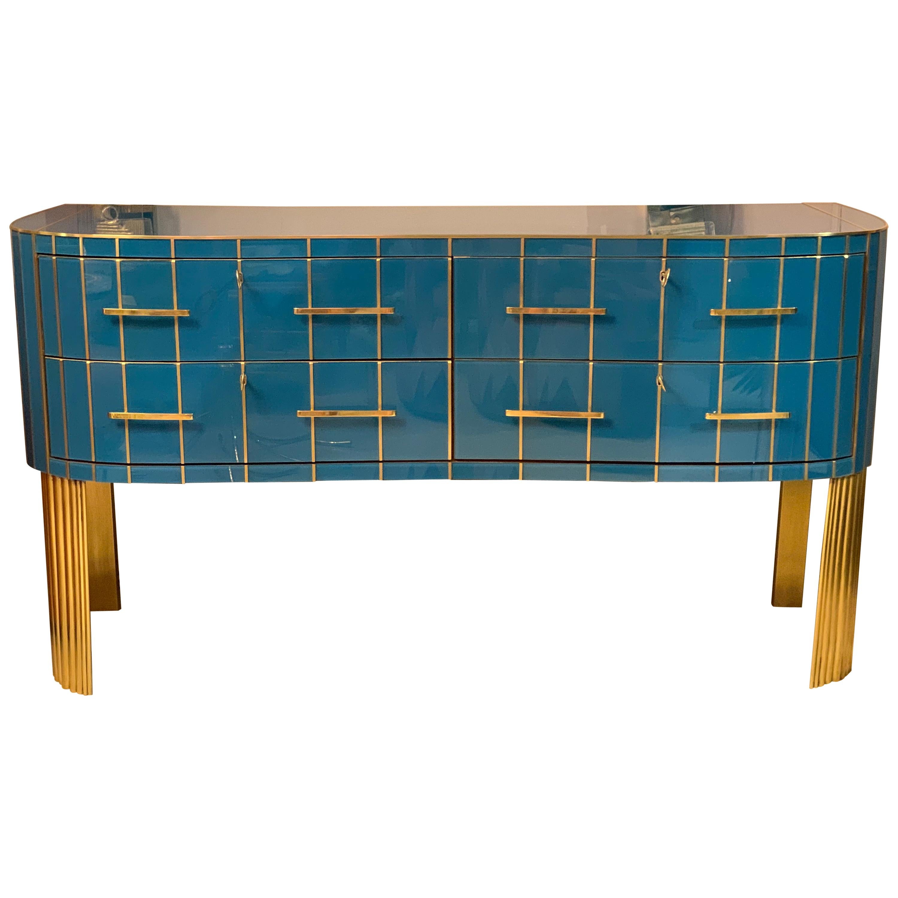 Italian turquoise opaline glass chest of drawers, brass handles, inlays and legs.
The chest has four drawers and the front is slightly rounded in the sense that it has a particular wavy front shape.
