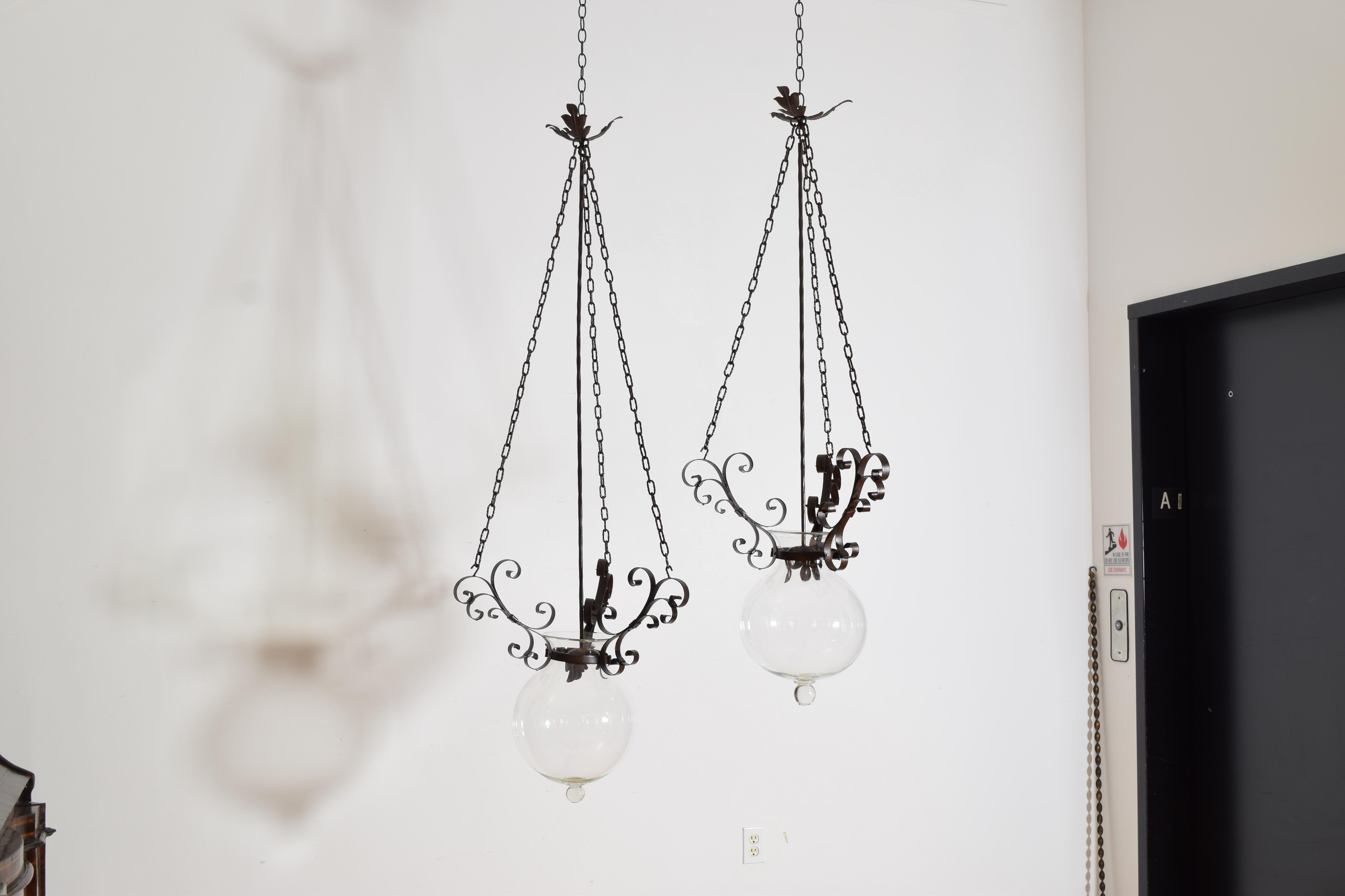 Hand Blown Murano glass globes are smooth, luminous and slightly imperfect showing the glassmaker’s personal touch.  The wrought iron scrollwork and floral finials reflect traditional Italian ironwork often made in Venice and Florence. 