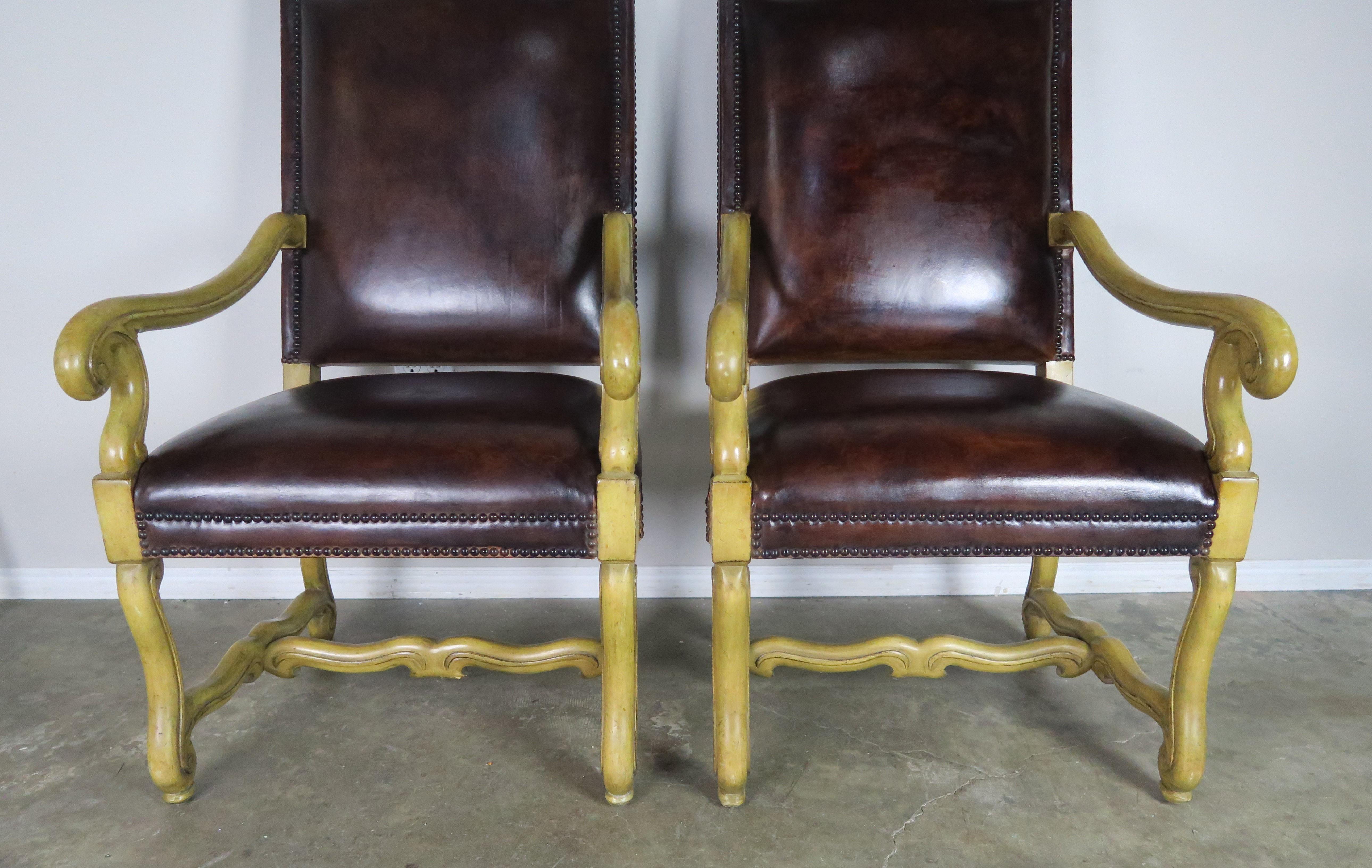 Pair of Italian walnut Tuscan style armchairs upholstered in rich tobacco colored leather and detailed with a double row of nailhead trim. Seat height 20