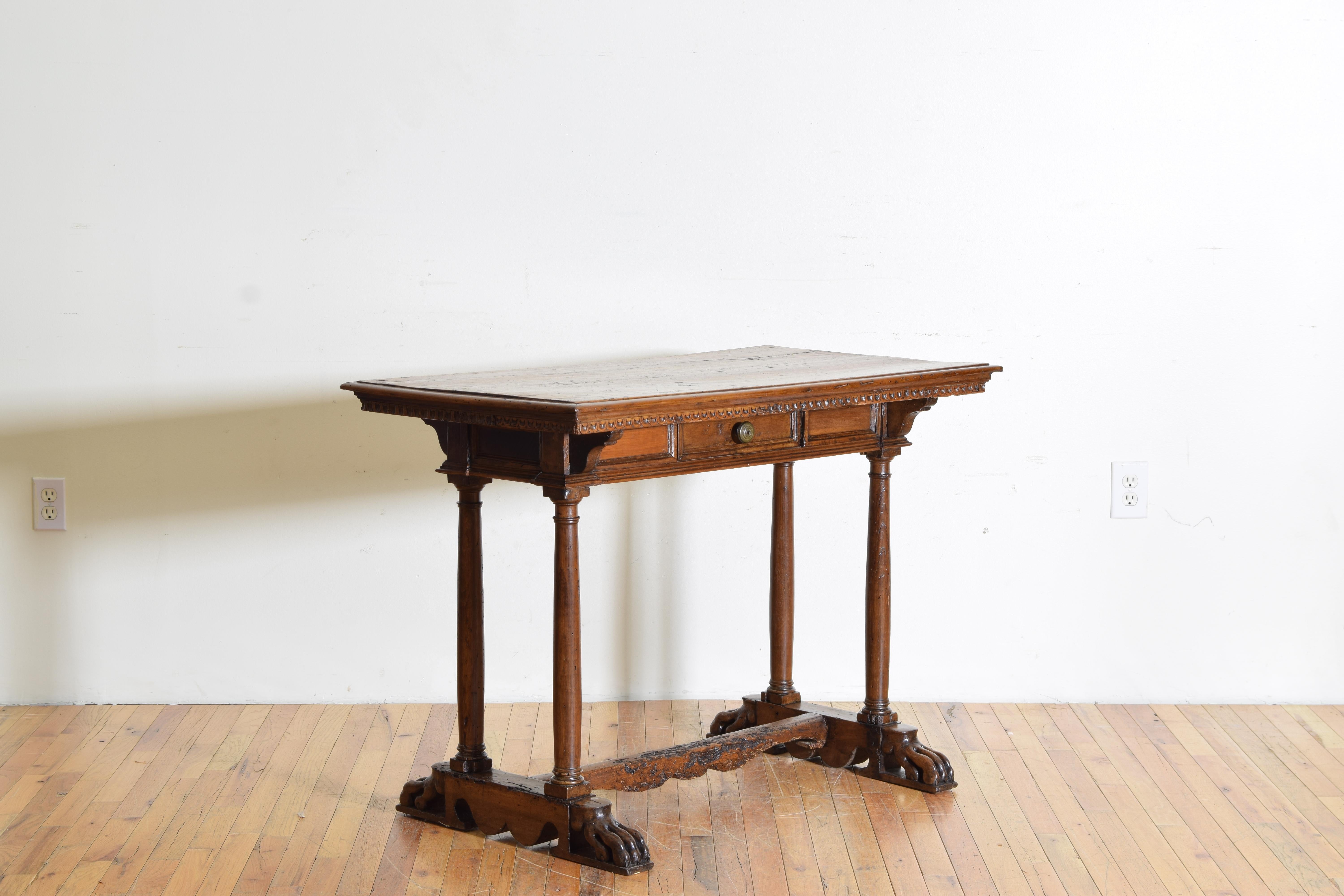 Having a rectangular top with molded edge and a dentil molded apron atop a paneled case housing one drawer, the case and top raised on columnar legs, the shaped bracket bases joined by an h-form stretcher and terminating in carved paw feet.