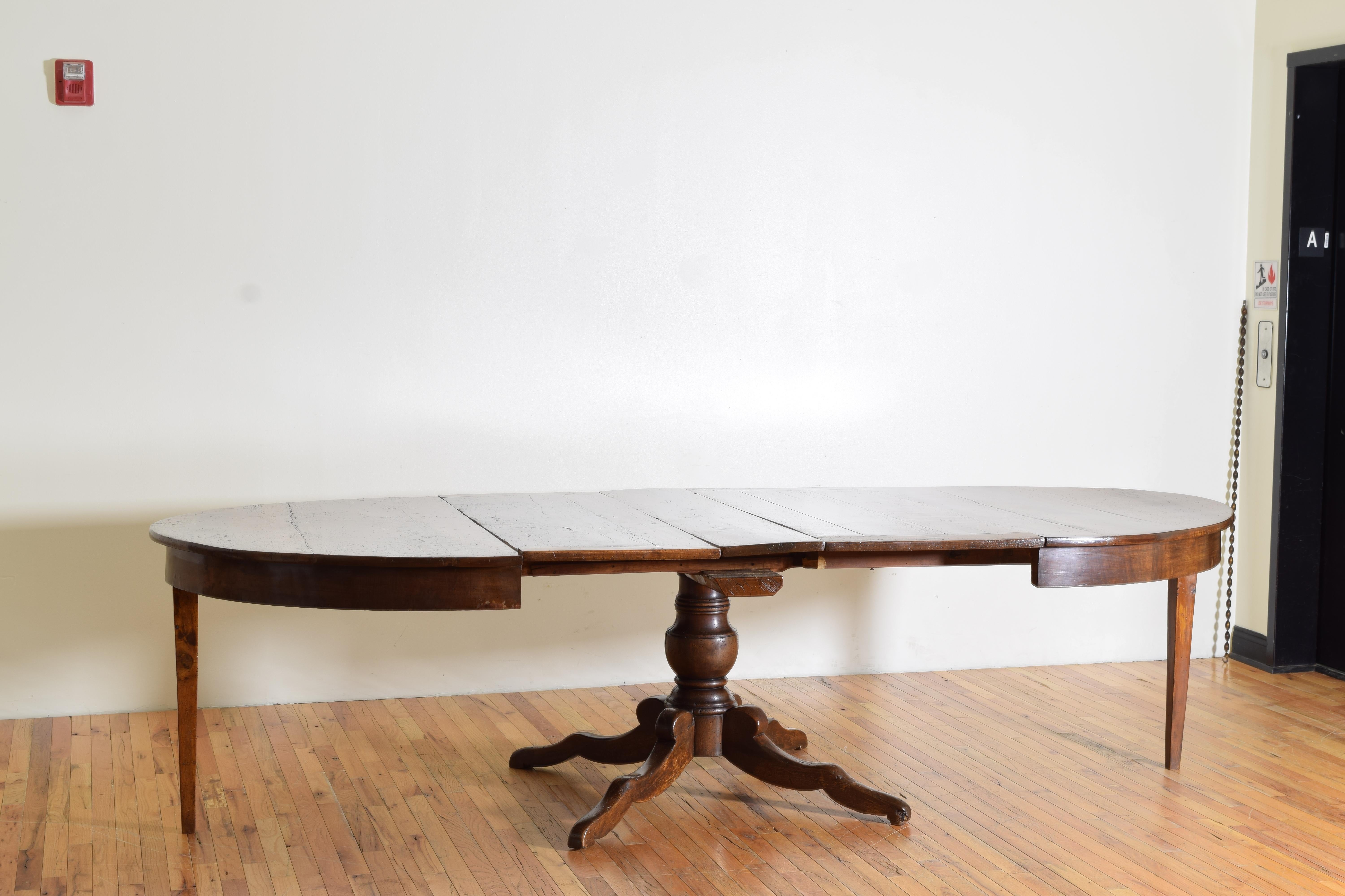 constructed entirely of solid Tuscan walnut and having an elliptical shaped top with a slightly recessed apron, the top opening to accept leaves.  As photographed with two of its three original leaves of 17