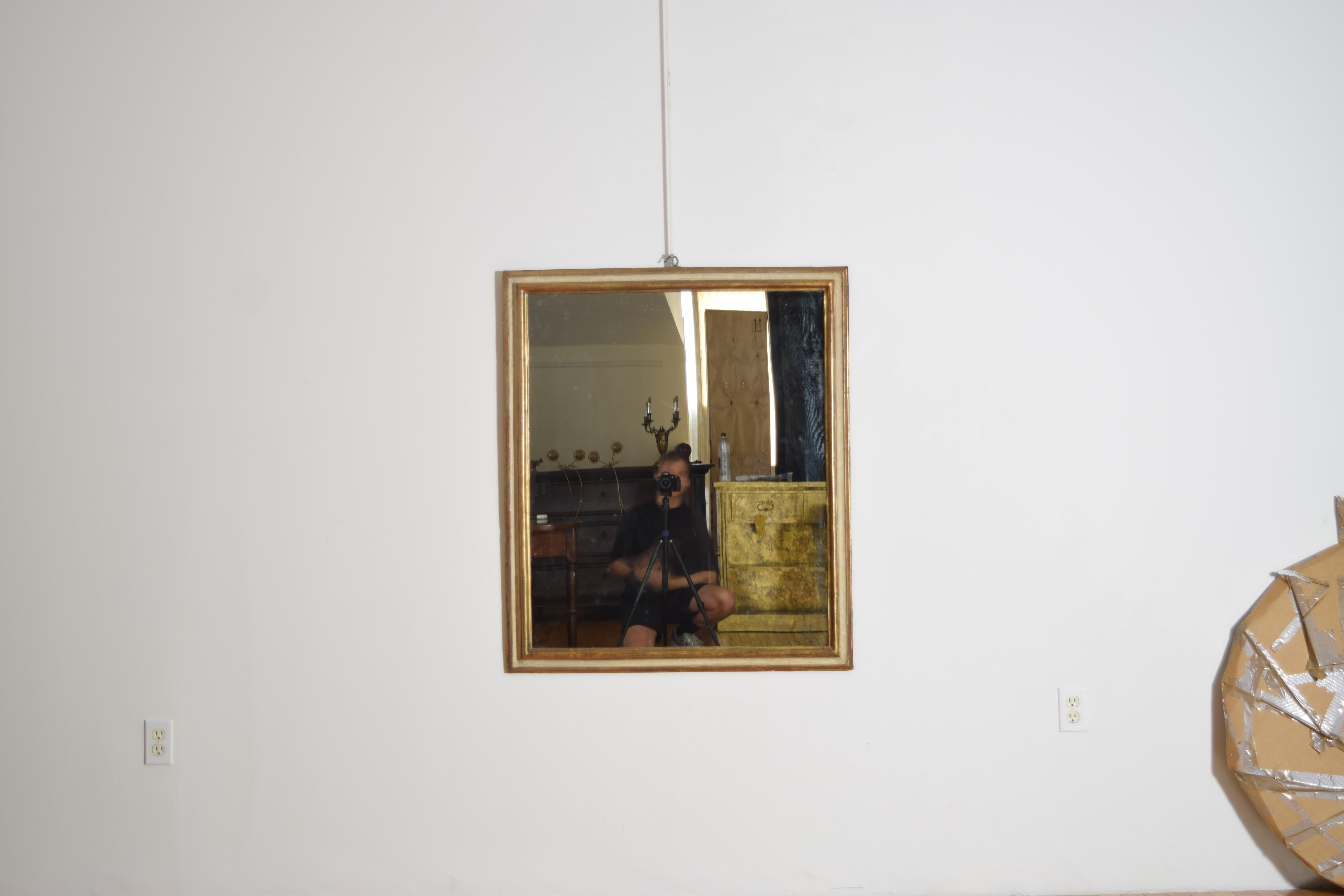 de forma rectangular y doble moldura, con la parte superior dorada y la inferior con la pintura original, ahora provista de una placa de espejo moderna