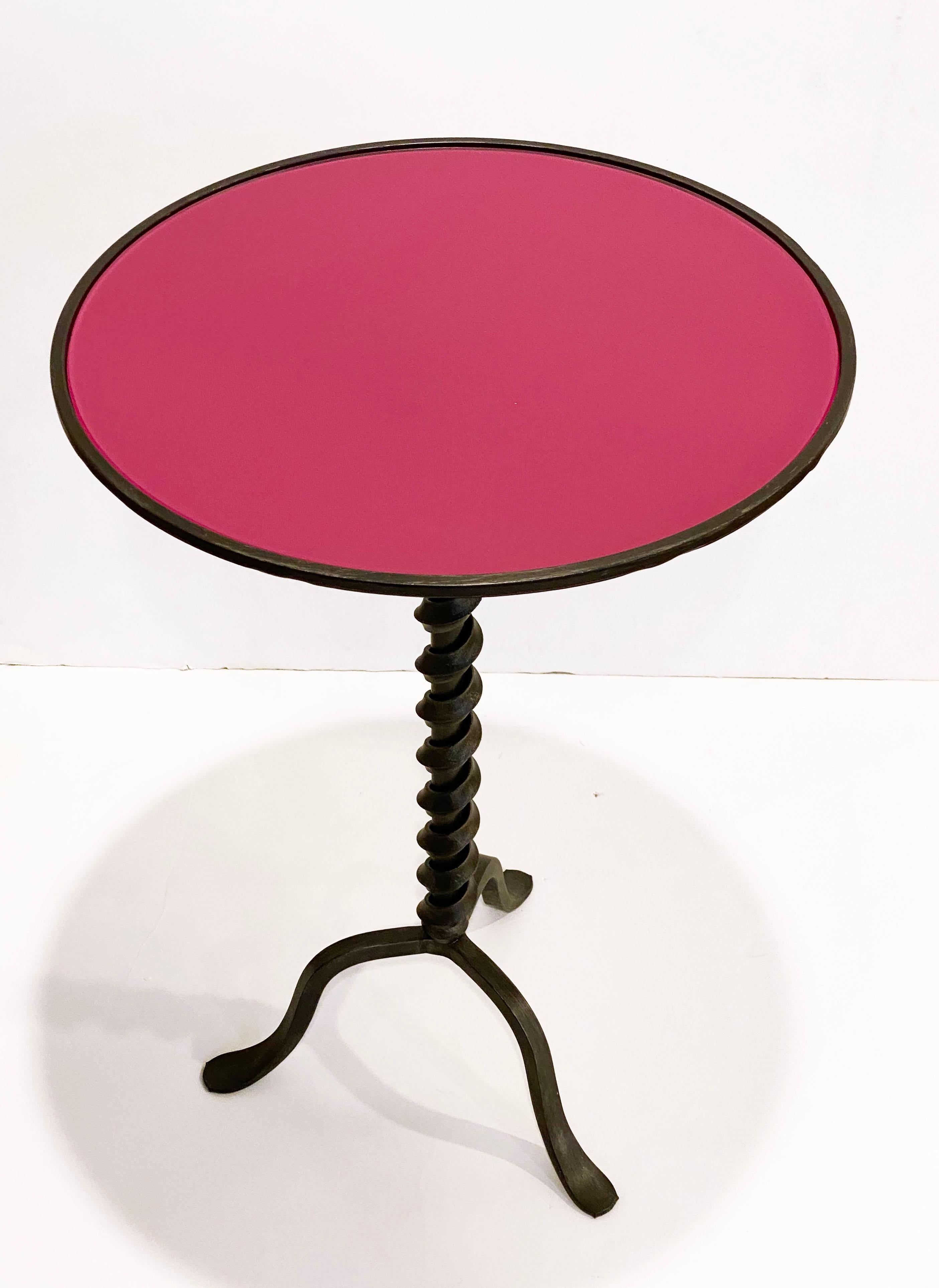 Add fun with color to your environment, outdoor and indoor! This contemporary cast iron side table, entirely handcrafted in Italy, will certainly delight with a glass top customizable in any color of your choice. This organic modern tripod piece