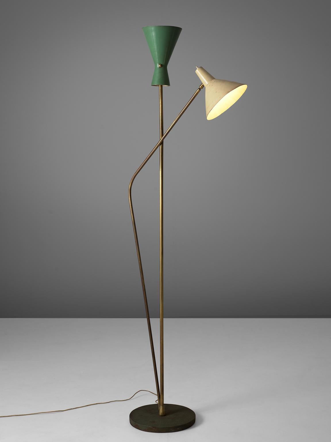 Lumen, two-armed floor lamp, brass and metal, Italy, 1950s.

This floor lamp is built up of one pedestal dark grey metal foot from which two brass stem arises. Each stem each end in a metal shade, one white and one green. The green shade is