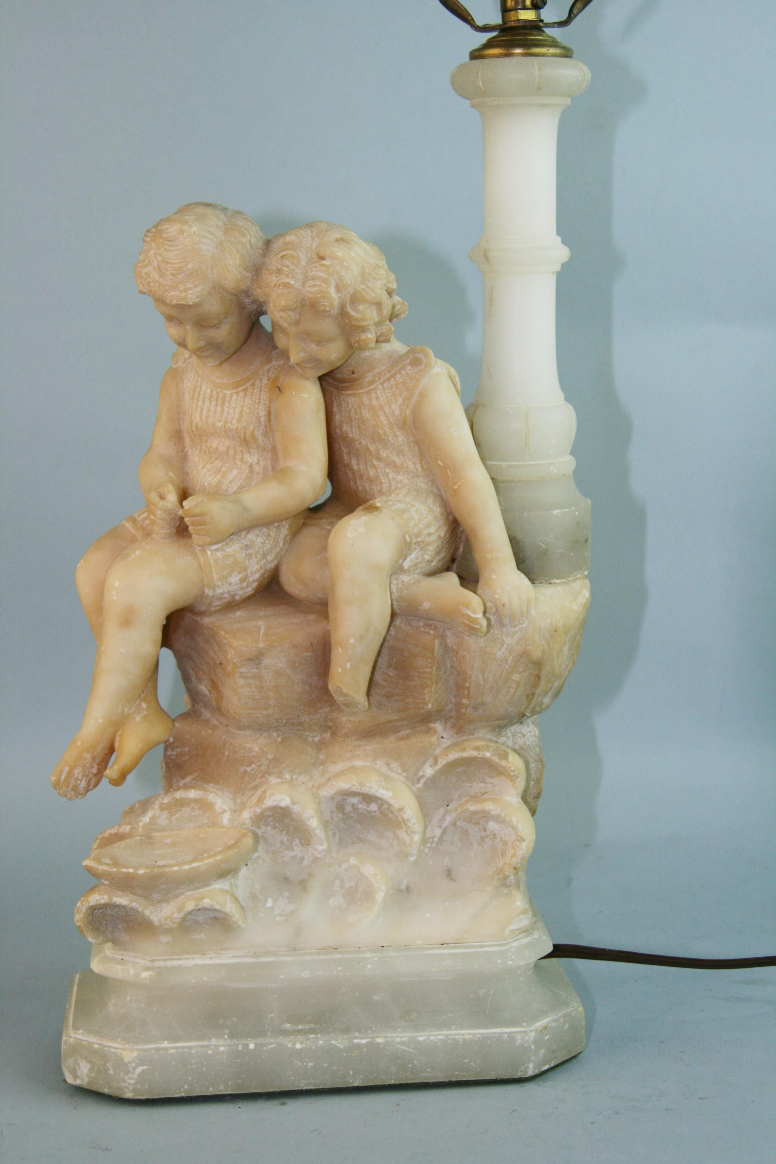1169 Italian hand carved alabaster sculptural lamp of two children
Existing wiring in working condition
Measures: Height 17