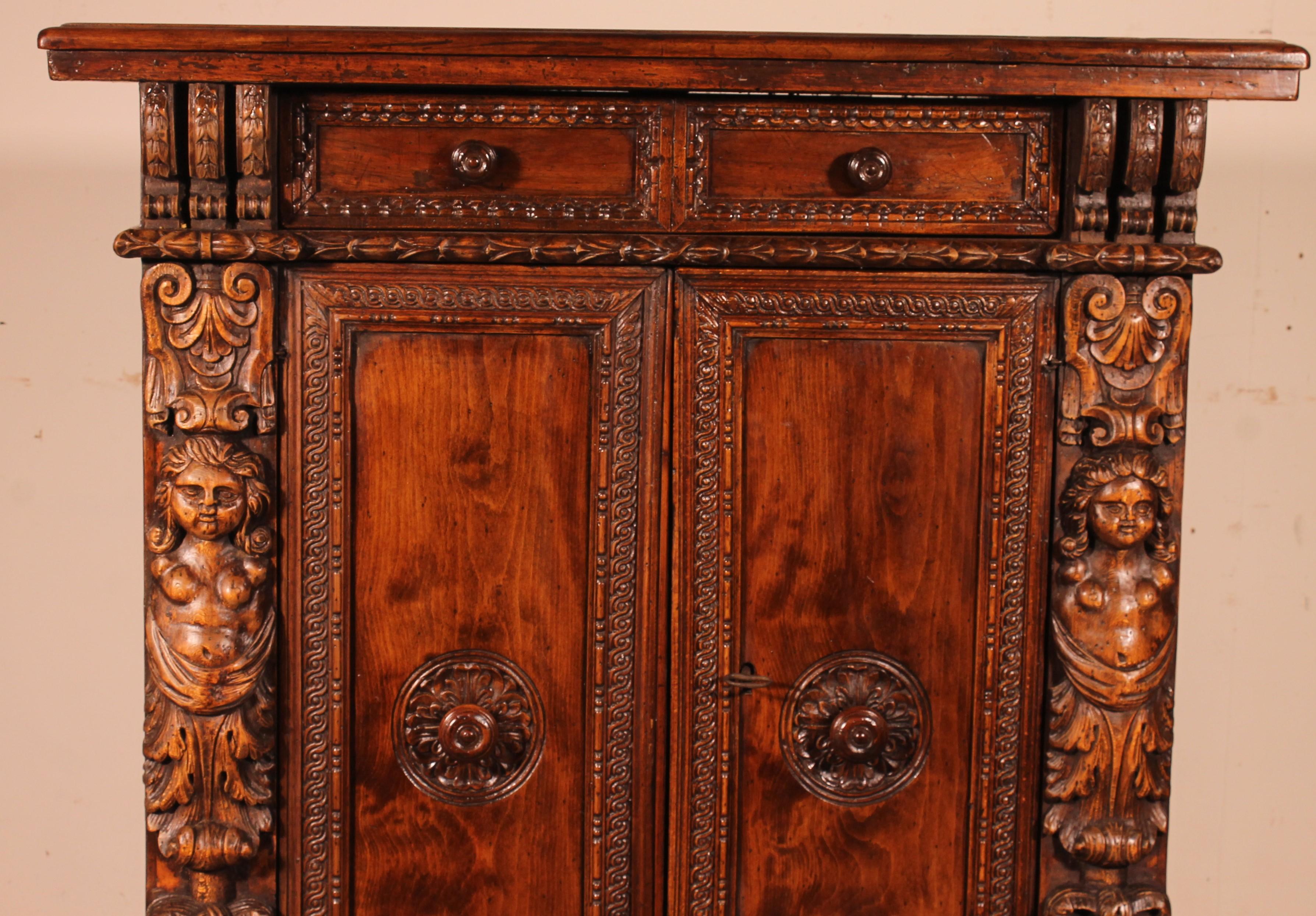 Italian buffet in walnut and fruitwood from the 17th century opening with two doors and which has a drawer

Very beautiful small model with a superb top with a nice patina and a beautiful thickness
The two Uprights are decorated with two