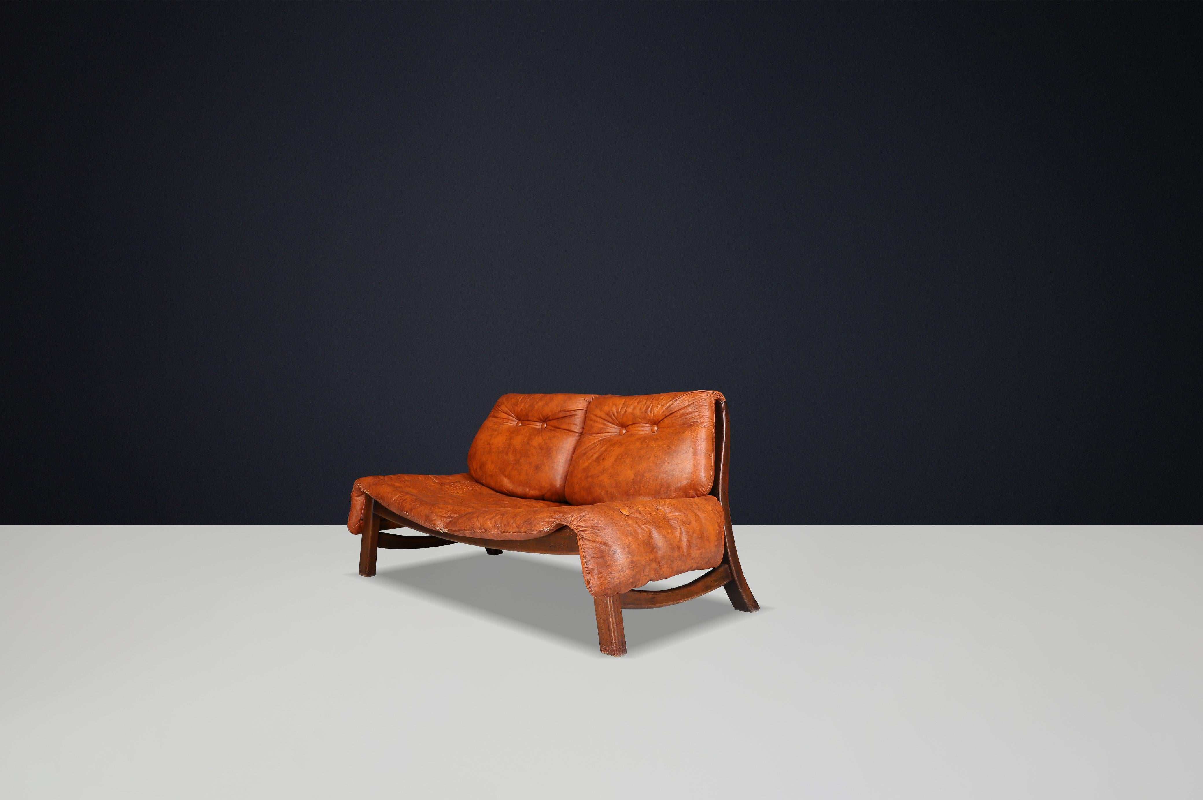 Canapé italien à deux places en noyer et cuir cognac, années 1960

Cet élégant canapé deux places de l'Italie des années 1960 est un exemple raffiné du design du milieu du siècle, alliant un savoir-faire sculptural à un confort luxueux. Avec son