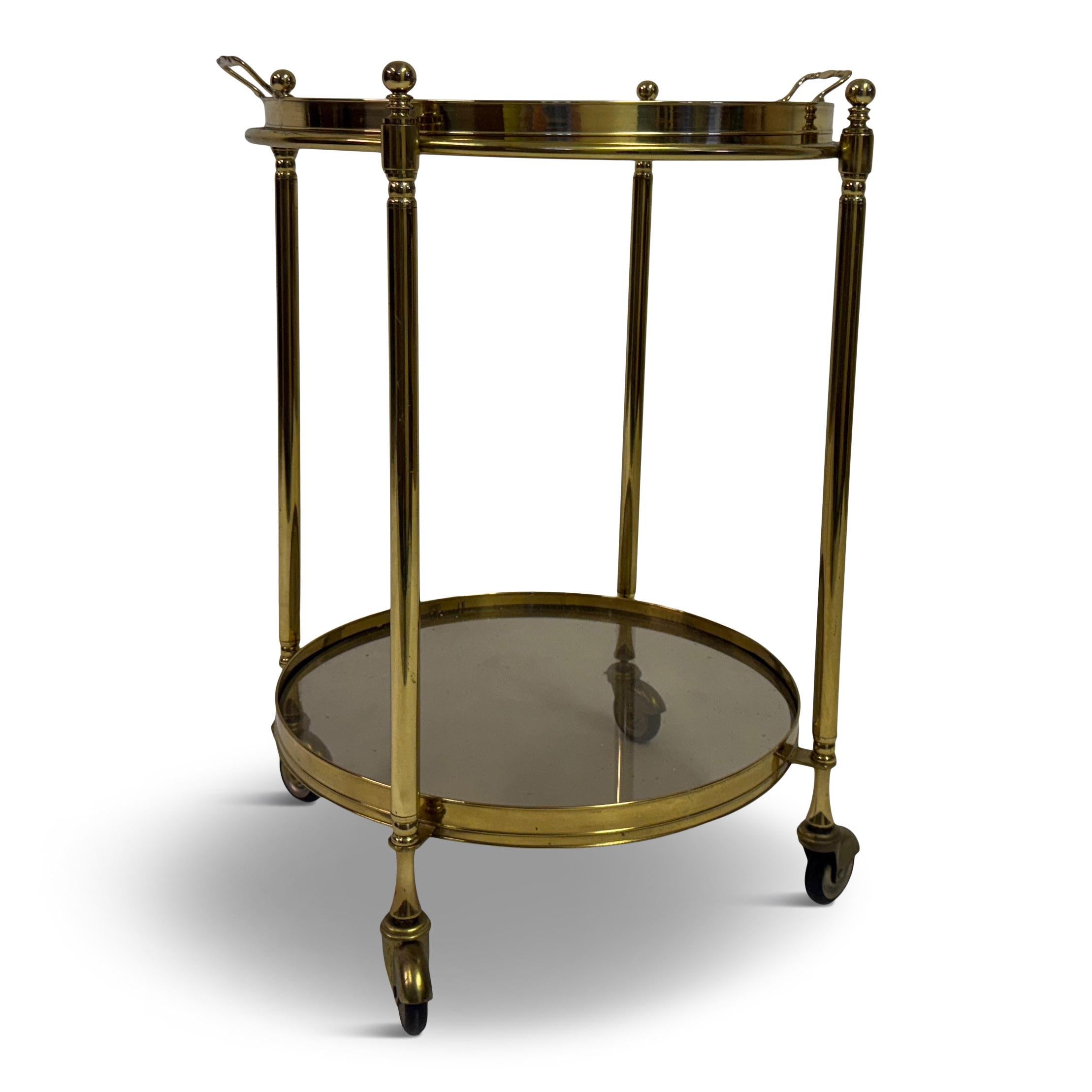 Italian Two-Tier Brass and Smoked Glass Bar Cart, 1970s

A refined and classically proportioned two-tier bar cart in polished brass with smoked glass shelves, Italian, circa 1970s. The design draws on neoclassical elements, with fluted uprights,