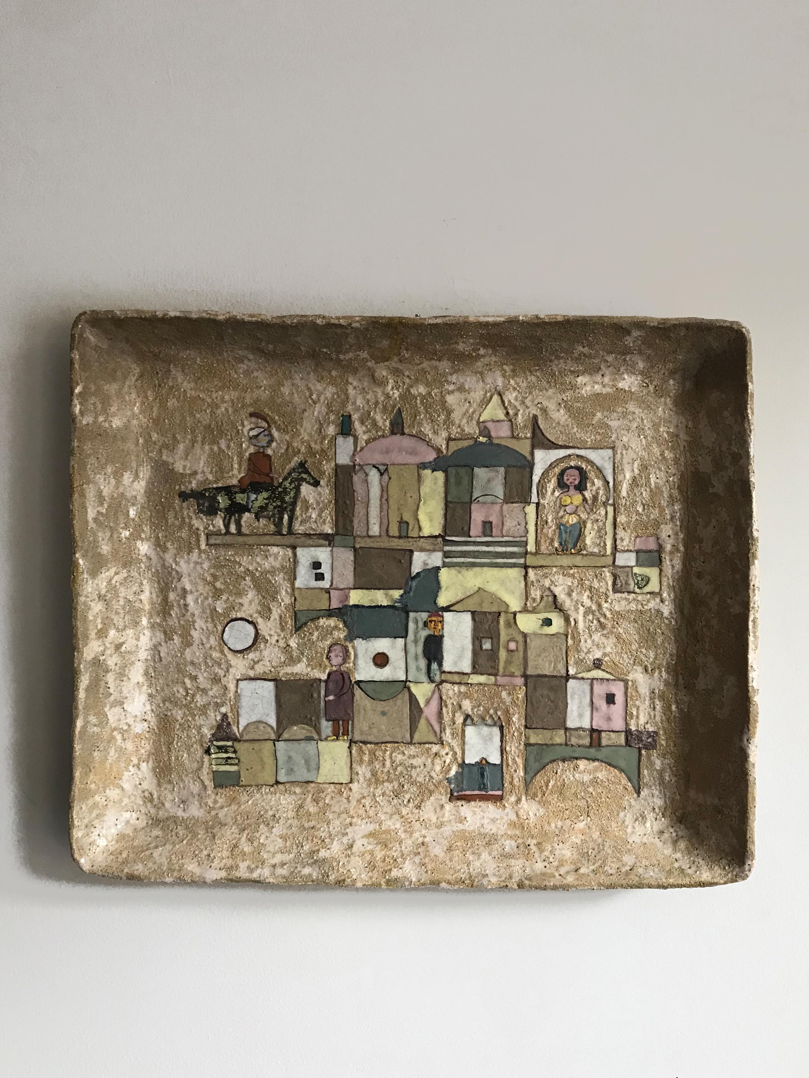 Italian midcentury modern design very large decorative ceramic wall tray designed by the Italian artist Ulisse Pagliari, background with rough workmanship decorated in polychrome with depictions of Houses and Figures,
with artist’s signature and