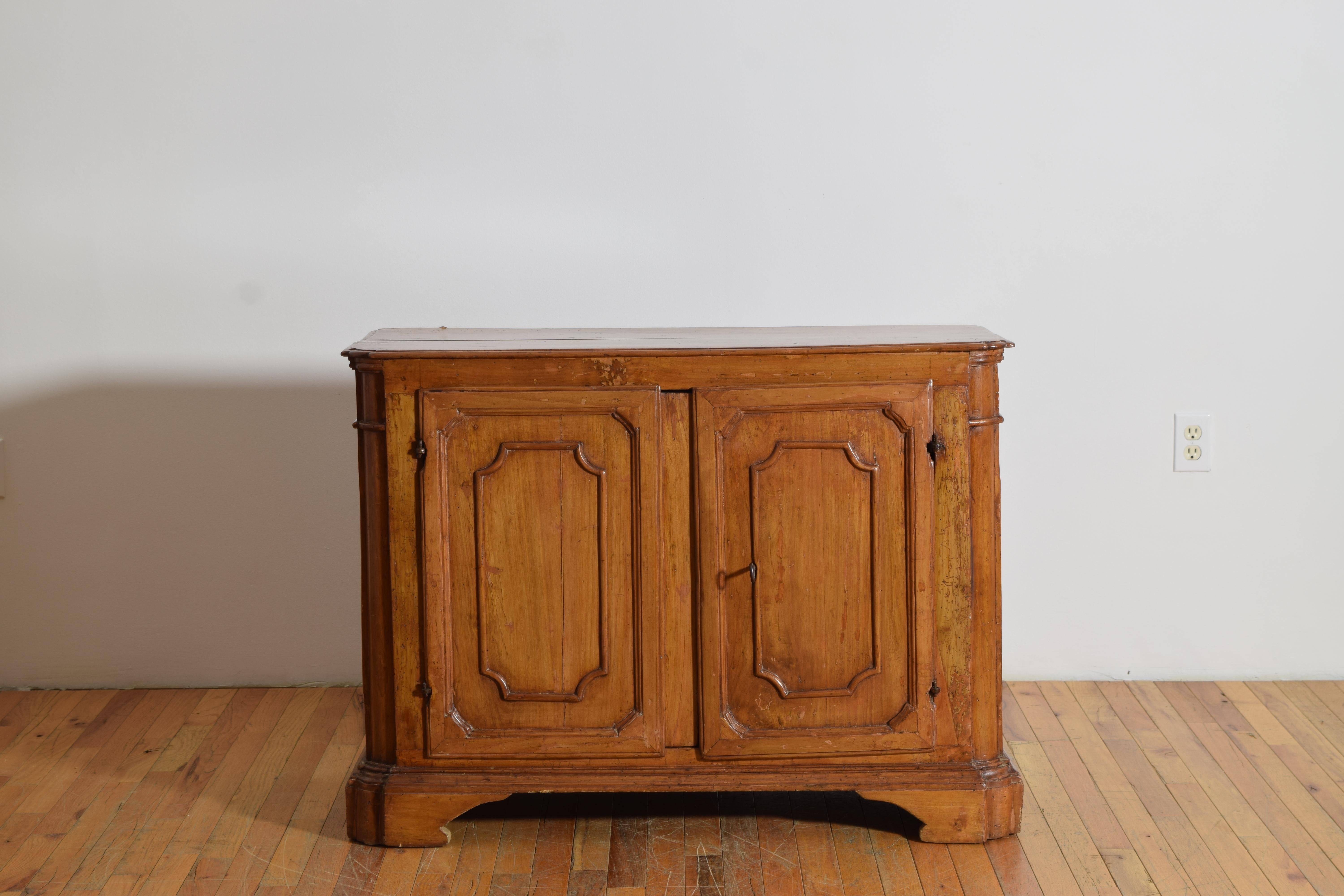 avec un plateau rectangulaire aux coins avant crantés et arrondis au-dessus d'un boîtier conforme abritant deux tiroirs avec une étagère intérieure, les façades des portes et les côtés étant recouverts de panneaux similaires, le boîtier reposant sur