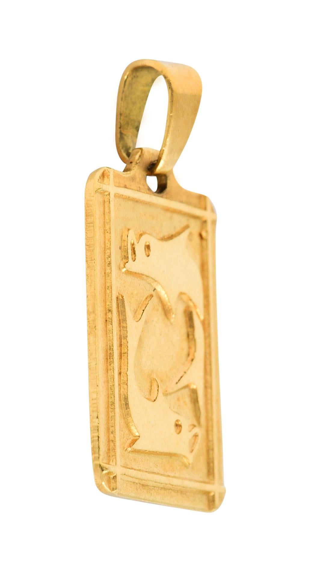Rectangular charm has a stylized depiction of two mirrored fish

Slightly raised and surrounded by an intersecting linear border

With Italian assay marks for 18 karat gold

Signed UnoAErre

Circa: 1970s

Measures: 7/16 x 7/8 inch

Total weight: 2.1