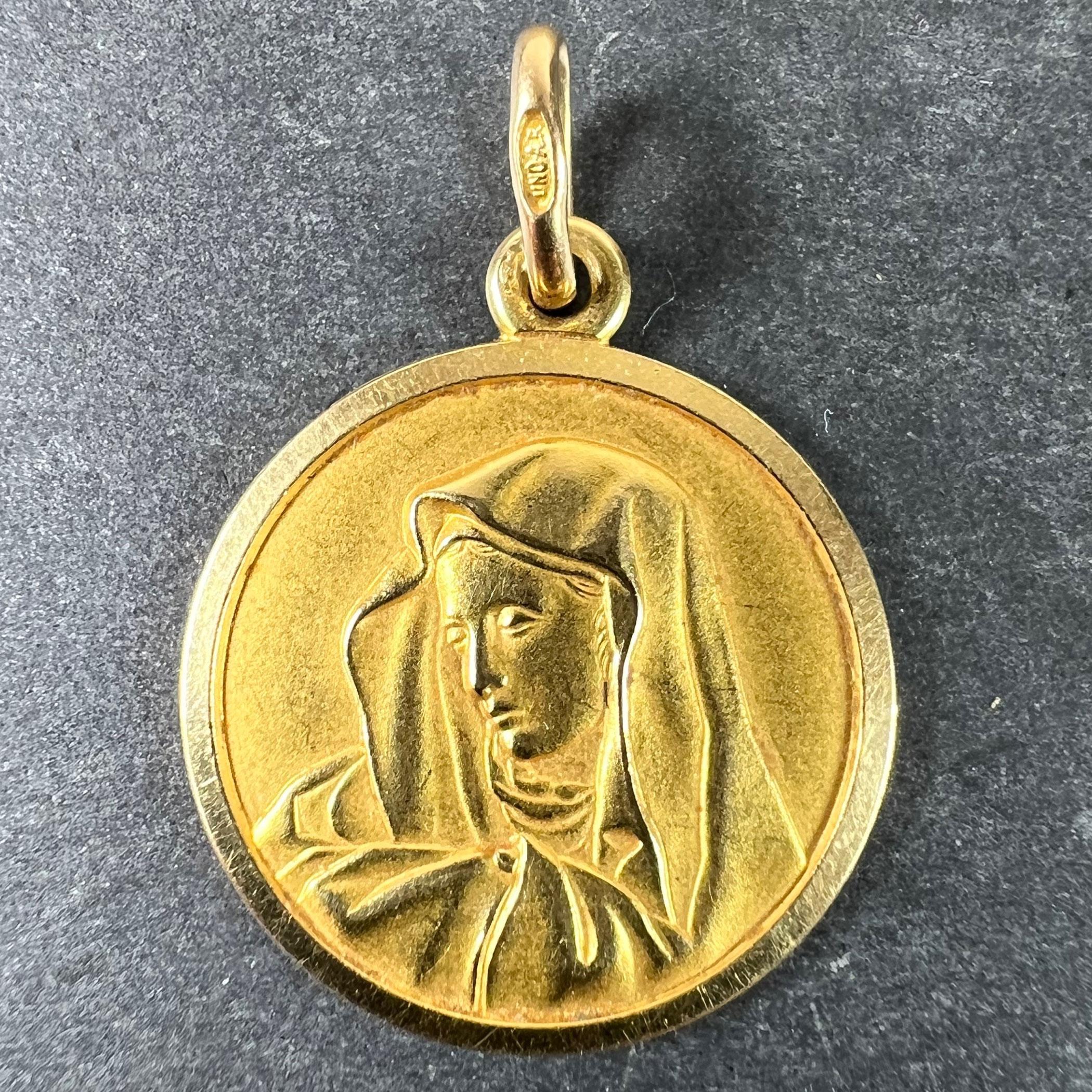 An Italian 18 karat (18K) yellow gold charm pendant designed as a round medal depicting the Virgin Mary. Stamped 750 for 18 karat gold, 1AR for Italian manufacture and UnoAErre, along with their maker's mark.

Dimensions: 2.2 x 1.9 x 0.14 cm (not