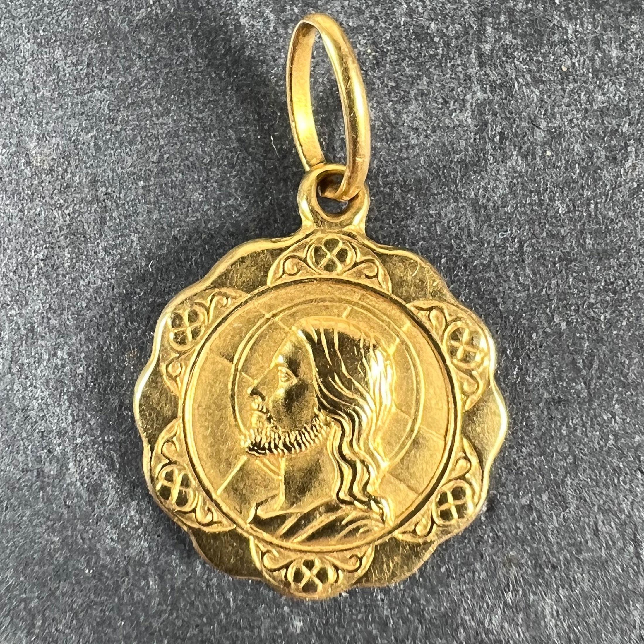 An Italian 18 karat yellow gold charm pendant depicting the head of Jesus against a cross on one side and a cross and anchor (indicating faith and hope) with the words 