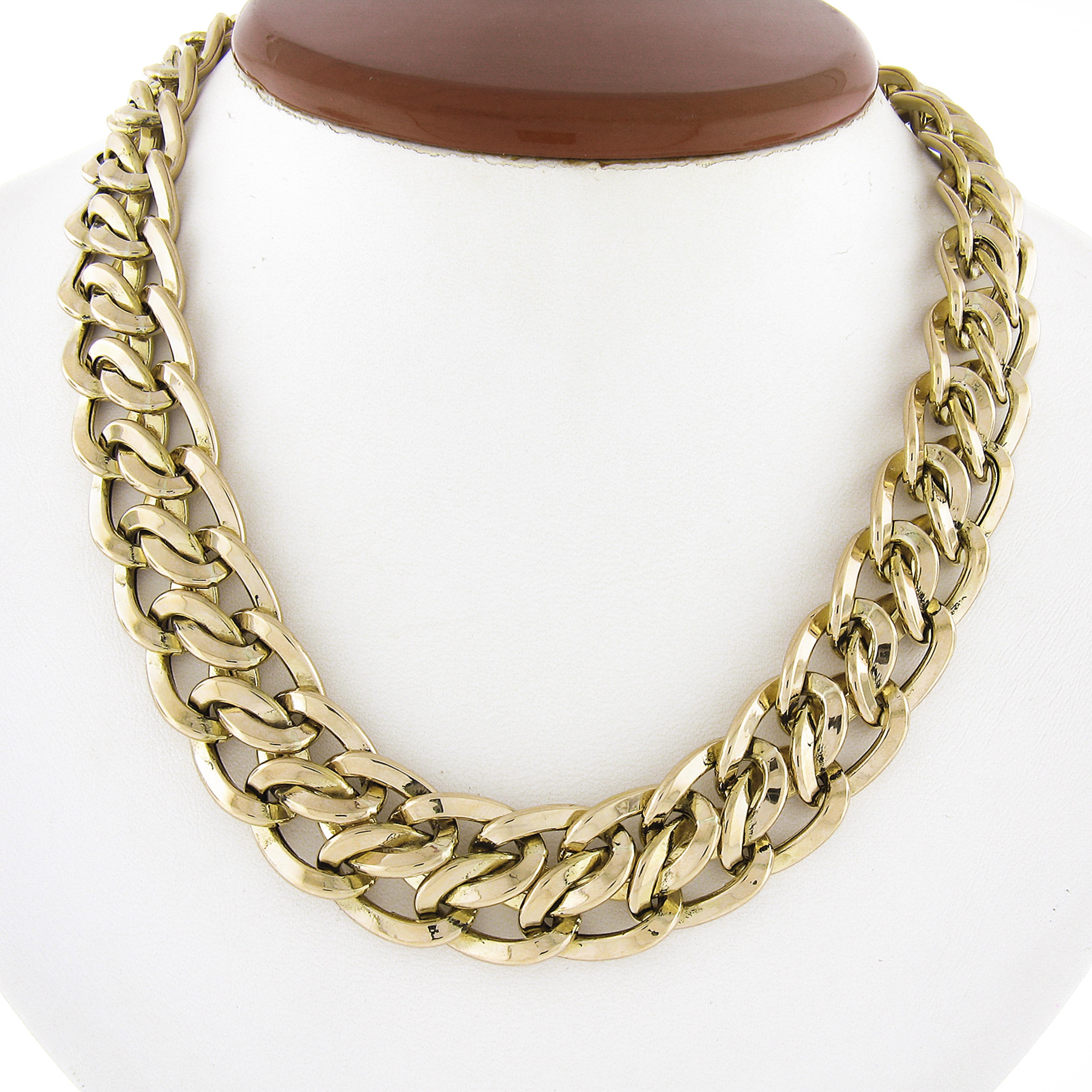 This Italian UnoAErre interlocking link statement chain necklace is crafted from solid 14k yellow gold. It features a wide polished finish elegant design. The necklace is in excellent condition! Substantial necklace with excellent neck coverage!