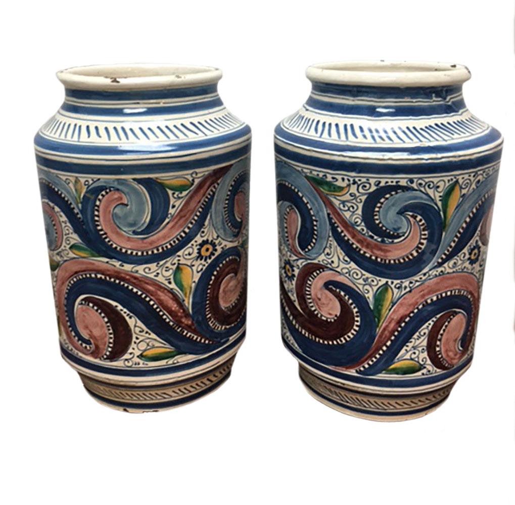Large pair of fabulous Italian urns with male figures with crowns. Swirls in blues and rose on the reverse. Circa 1780-1800.
