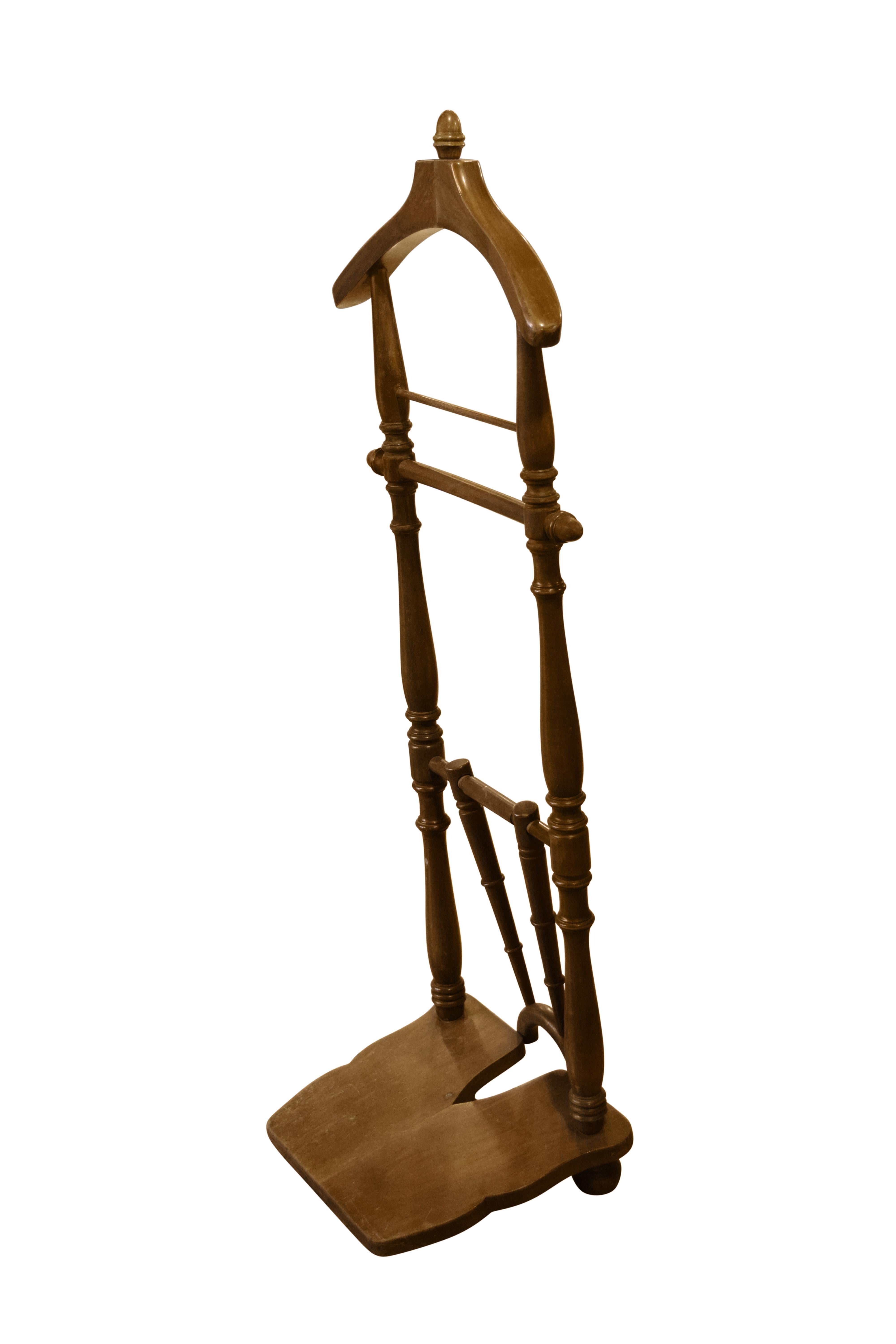A mid-20th century Italian walnut valet stand with coat and pant hanger and a boot jack.