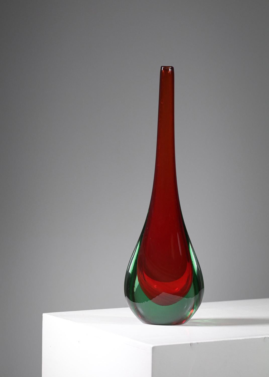 Très joli vase en verre soufflé de Murano des années 60. Excellent travail artisanal avec une belle nuance de lumière rouge qui met en valeur le design simple et épuré de la goutte de vase. Très bon état vintage (voir photos).