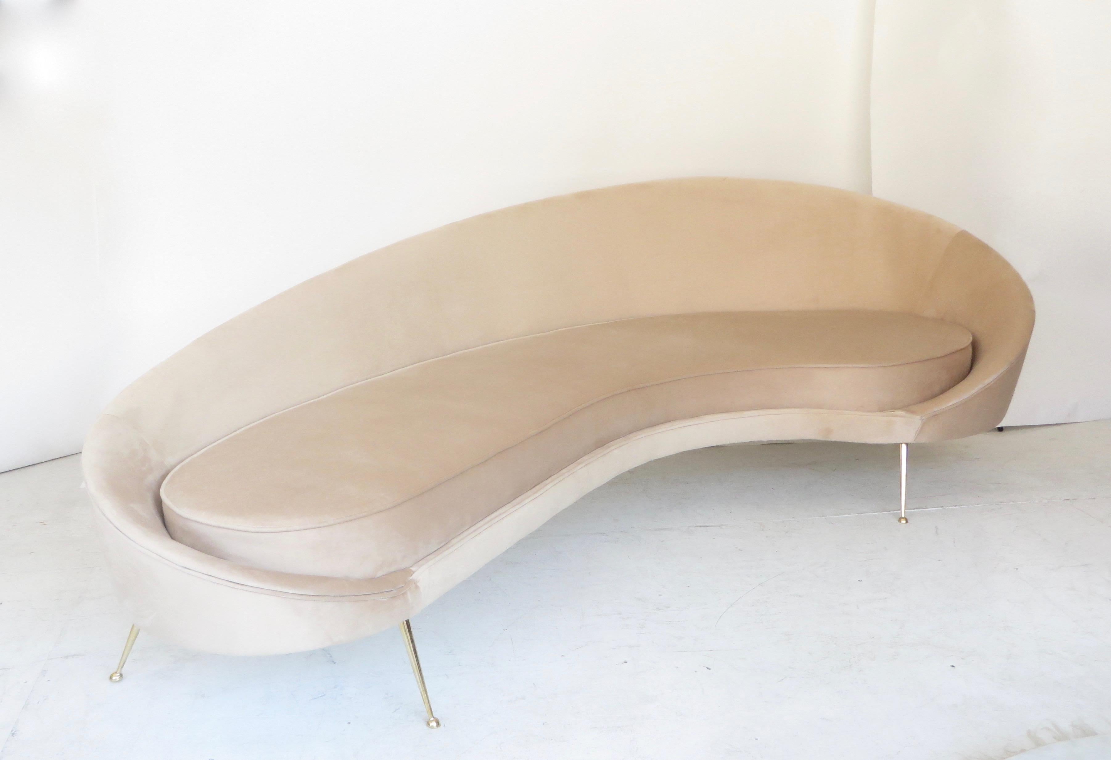 Italian pale cream blush velvet upholstered sofa with polished brass legs in the style of Federico Munari.
Totally restored body and cushions. The curving form allows it to be placed in many room configurations as it looks good from the back as well