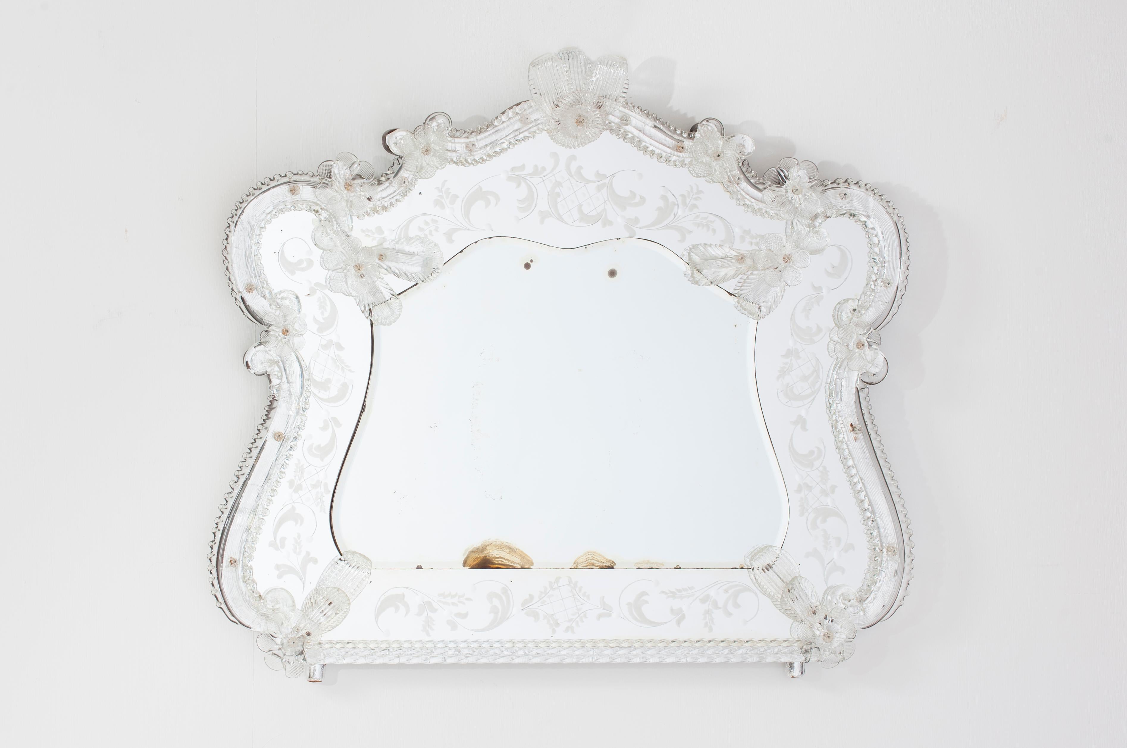 Venezianischer Spiegel aus geblasenem Murano Glas klar mit Blumen 1960er Jahre
Der Spiegel ist völlig transparent und hat einen silbernen Hintergrund, der den Glanz eines echten venezianischen Spiegels erzeugt. Der gesamte Rand ist mit