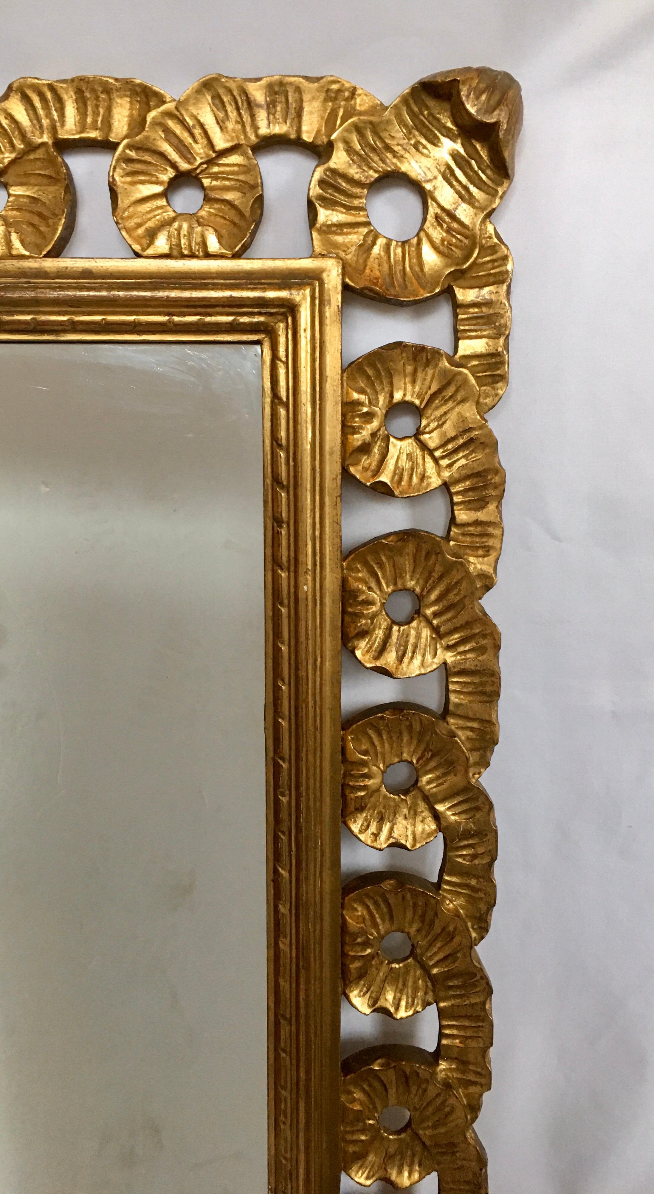 Beautifully detailed Italian Venetian wall mirror featuring a hand carved fluted and scalloped ribbon design. This large sculptural rectangular giltwood wall mirror can be mounted both vertically or horizontally.