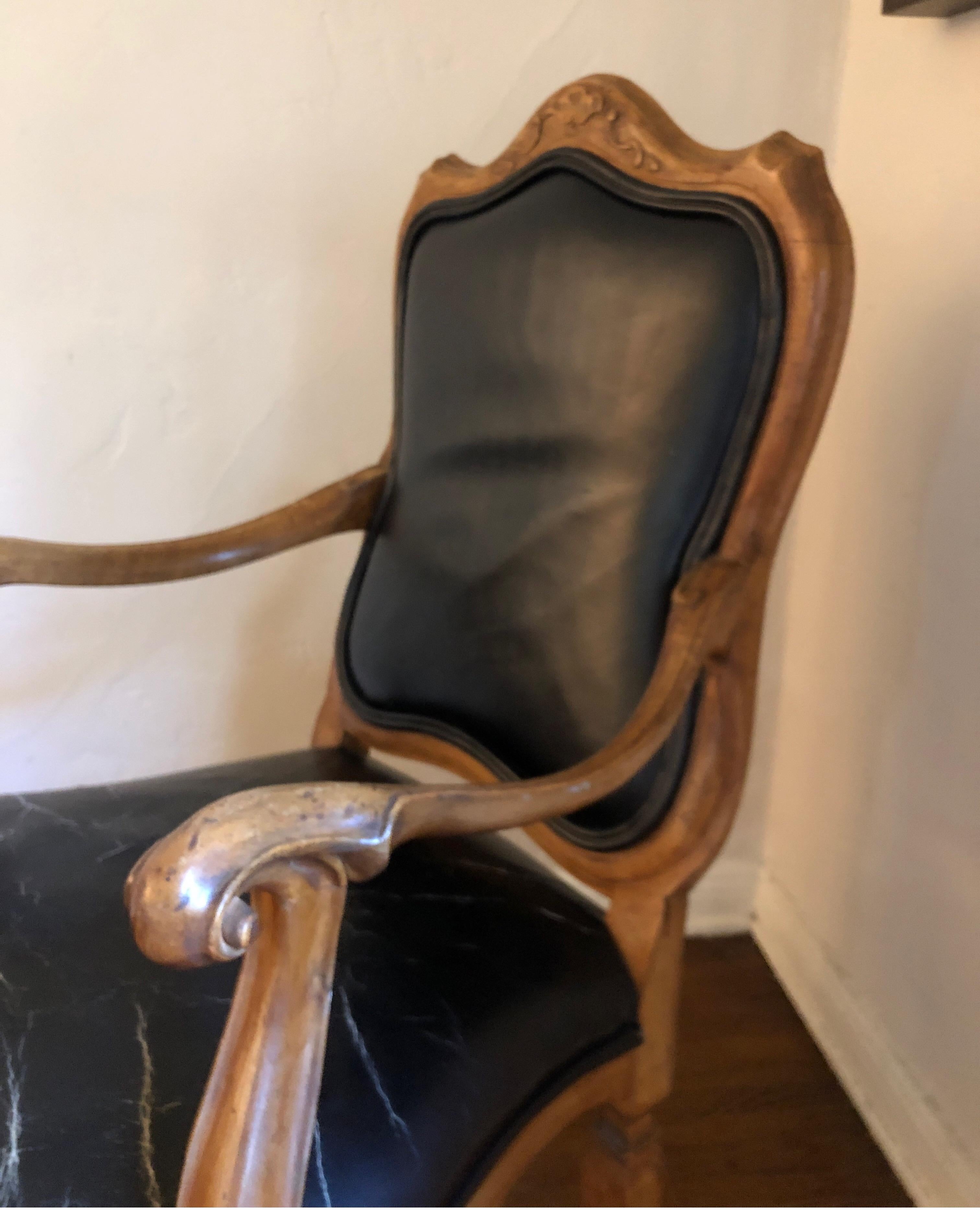 Exceptional carved Venetian style chair made in Italy.
Perfect size for a desk.
Carved details along the back and chunky curved grip on hand-rest.
Black leather upholstery has heavy wear on seat cushion. 

Very structural in modern setting.