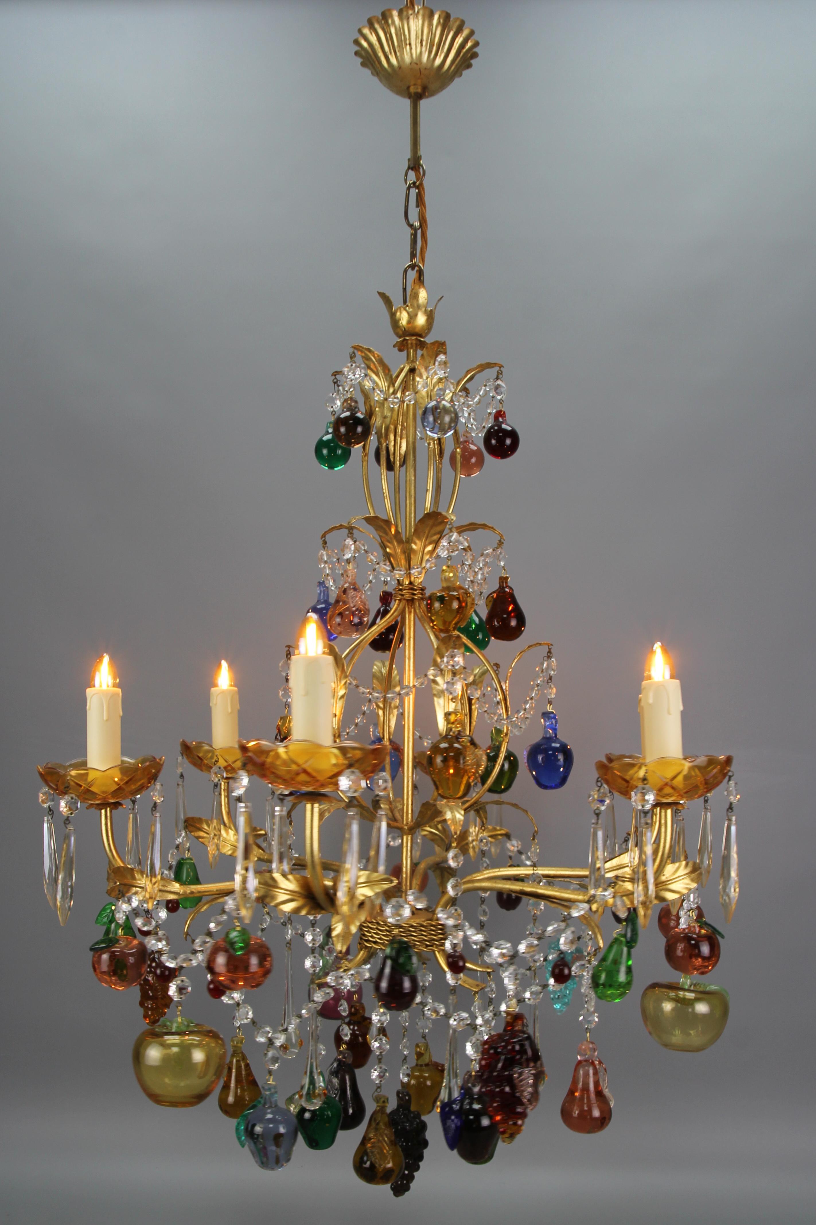 Italian Venetian gilt metal 6-light chandelier with Murano glass fruits and berries from the late 20th Century.
This impressive and beautiful Italian Hollywood Regency-style gilt metal chandelier features six chandelier arms adorned with