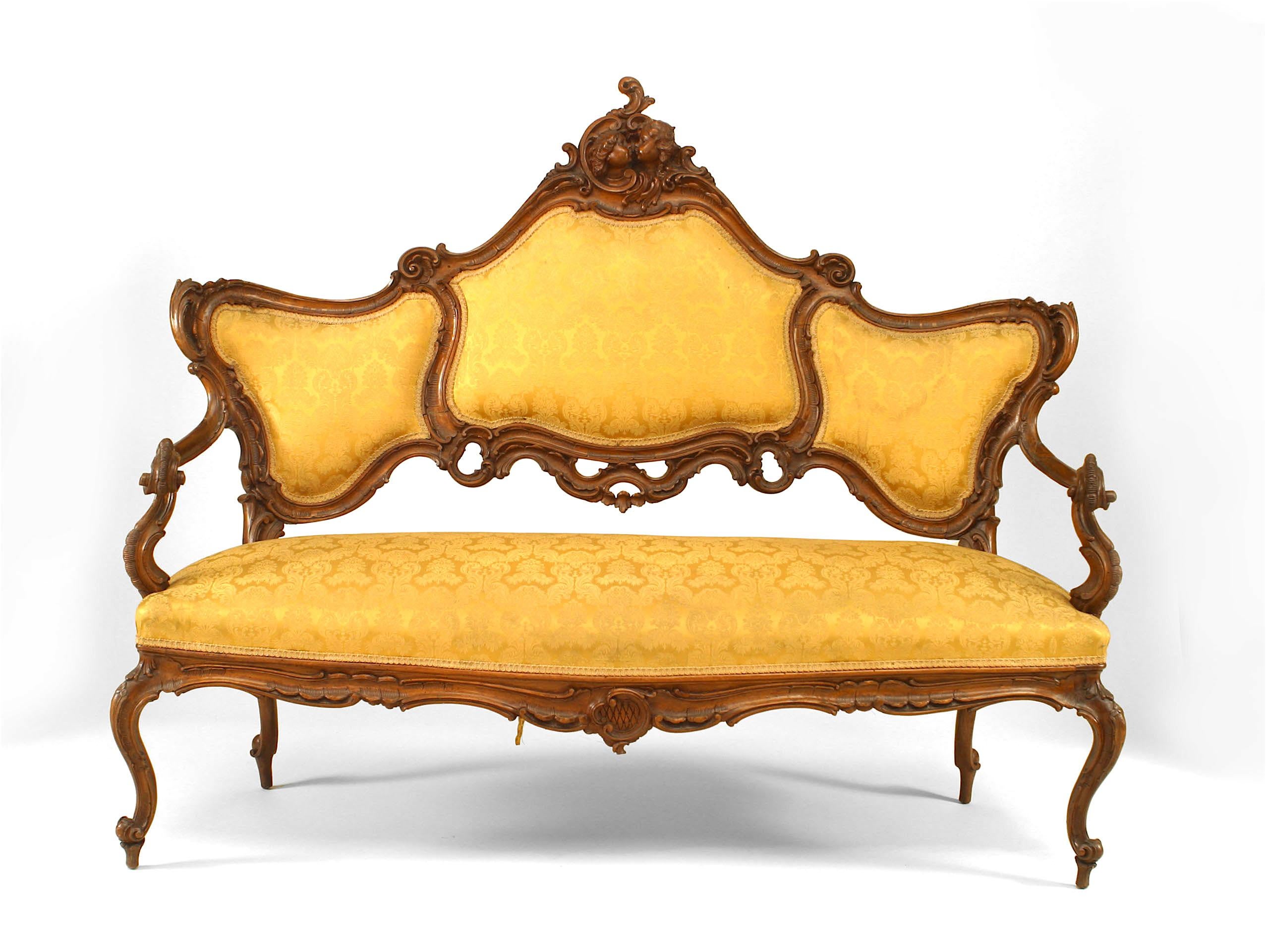 Ensemble de 6 fauteuils de salon de style vénitien (19ème siècle) en noyer avec têtes de cupidon sculptées et tapisserie dorée. (3 chaises latérales, 2 fauteuils, 1 causeuse)
